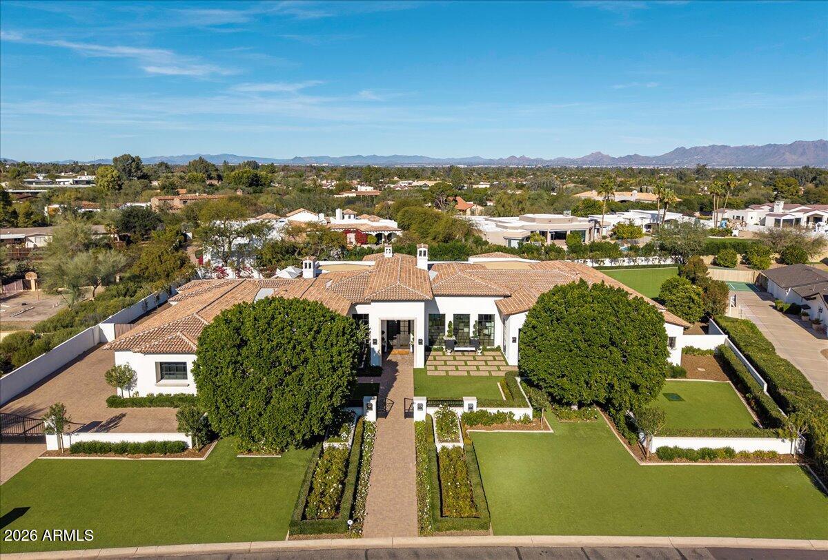 This private gated modern mediterranean inspired estate is absolutely spectacular. Custom built by Regal American, the pristine attention to detail and authentic european design elements makes it one of the most spectacular estates in all of Paradise Valley. The sleek architecture and chic design combine elegance and comfort, while incorporating contemporary elements and maintaining a sense of luxury and sophistication. Meticulous attention to detail elevates the overall quality of each room including the island kitchen that features exquisite custom cabinetry and a wolf/subzero appliance package. The stunning great room is the center of the home and has a floor to ceiling fireplace providing an excellent backdrop. The bar/game room has a full wet bar, plenty of room for a pool table, and glass doors that open to the phenomenal backyard. There's a temperature-controlled wine room that stores nearly 1,000 bottles, and the entire home is automated with a Control4 system. All 5 bedrooms and 6 baths feature beautiful custom touches, with a resort caliber primary suite. Some of the extraordinary finishes include neutral walls, polished and matte countertops, textured tile, natural stone, and substantial millwork, and the backyard is nothing short of a dream featuring Berghoff designed landscape highlighted by flower gardens, meticulously manicured greens, an artificial turf covered yard with room for a pickleball/sport court, huge custom pool with a swim up bar and 25m lap pool, two separate ramadas, unique waterfall/rain curtain with LED lighting, and a separate pool bathroom. This special property has perfect elements for all generations to enjoy making it a highly desirable family compound!