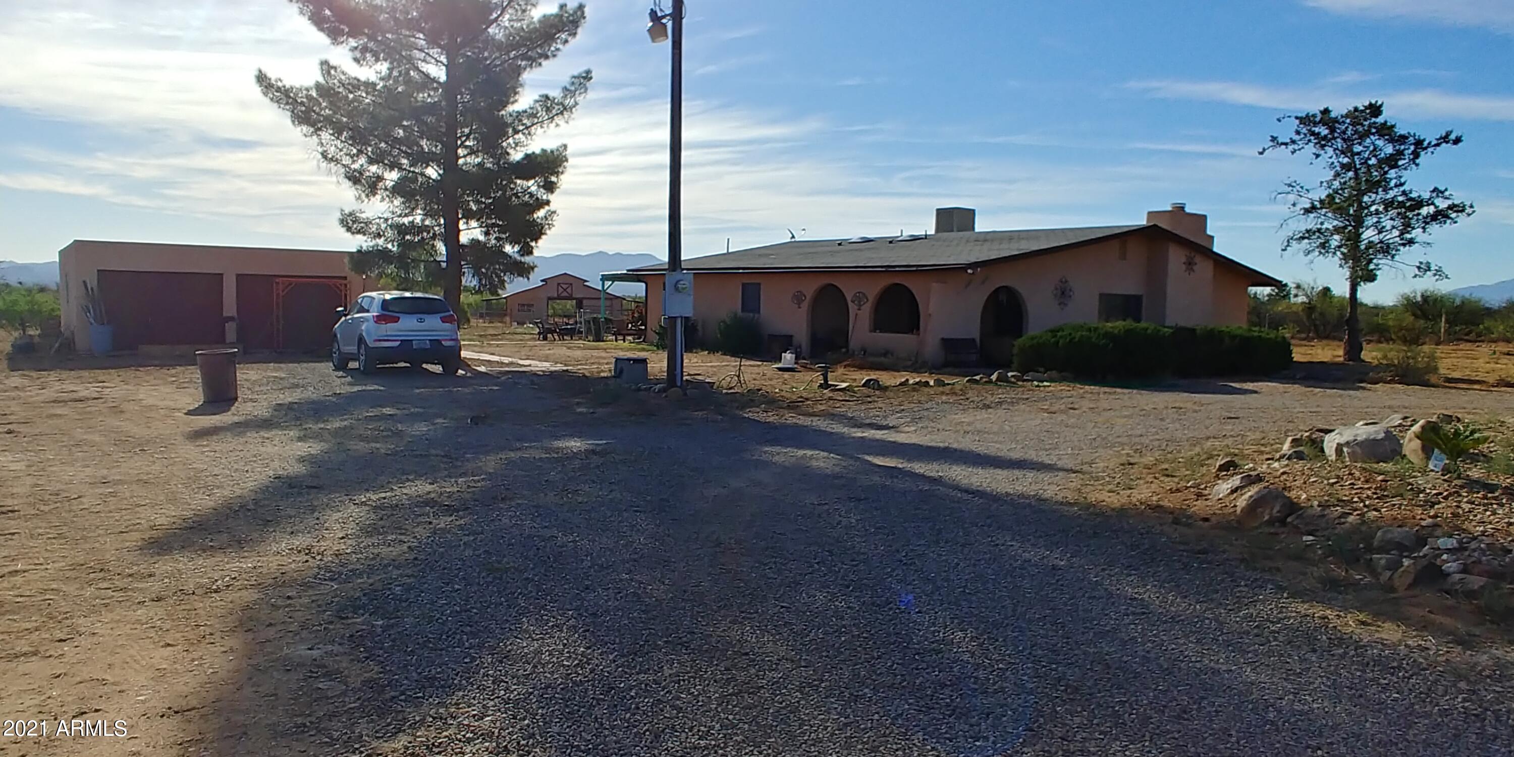 What an opportunity to purchase a great home with a 7 stall barn, detached storage, tack, feed bldg, fenced and cross fenced and 2 separate stallion pens. There is a private well drilled in 1983! The home features updated tile and laminate flooring, lovely baths and the kitchen has granite tile counters and newer stainless fridge. You will love all the living spaces, there is a sunken living room with a real fireplace with blower, large family room and a lovely Arizona room that is NOT included in the sq ft, making this home over 2000 sq ft. There is what the owner calls the solar room that is a lovely bright room that would be great to waltch the monsoons come in this summer. All this and great mountain views and just off the paved road! Call me today before it is too late!