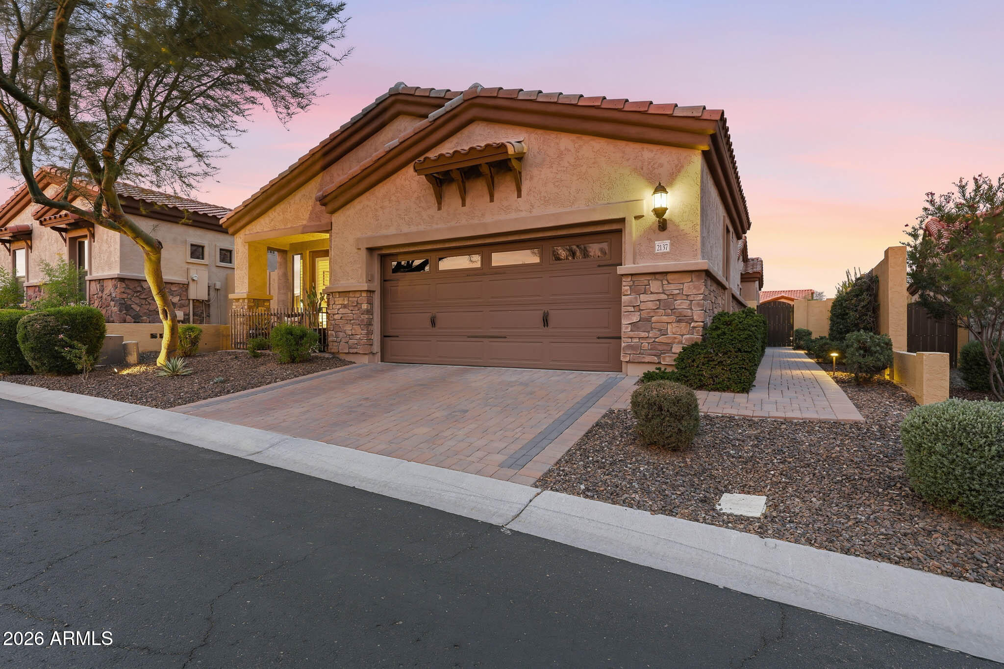 This original Builder's  Bella Via MODEL Villa 3 in Mountain Bridge is the pride of the community, and will not disappoint in any way, inside and out!  It showcases numerous  upgrades, designer touches, and significant recent improvements completed by current owners. A welcoming Courtyard leads to the open, spacious floor plan, ideal for entertaining. Wood-look Tile flooring, plantation shutters, abundant natural lighting, ceiling fans, recessed lighting, crown moldings, 10 ft. ceilings and Kitchenaid gas gourmet Kitchen with all the desired components are just a few of the many exceptional features.  Entering the Pergola covered Patio from the Great Room 15' Wall of Glass, the private rear yard is a Resort Haven with gas fireplace, putting green, lush landscaping and built-in  BBQ Island. The Primary En-suite has beautifully upgraded tile, mirrored closet doors and garden door to rear patio. The second bedroom features double garden doors leading to the front patio to enjoy memorable sunsets.   The Den with archway could readily convert to third bedroom but works well as a bright, open home office. The sound system services the Great Room, Primary Suite, Den, and Rear Patio. The two-car garage is equipped with extensive, built-in storage cabinetry, 23 SEER Mini Split AC, extra insulation, epoxy flooring, tinted windows and garage door upper glass accent, creating a multi-use space for a studio or workshop.  This is a true "move-in ready" home that emanates pride of ownership throughout and offers a near "maintenance-free" lifestyle.
Please refer to the Schedule of Improvements in the Documents tab for all details pertaining to the many enhancements and upgrades.  

HOA Fees include exterior maintenance and painting, front yard care, roof repair and replacement, and common area maintenance. Bella Via Residents enjoy their own, private heated Pool and Spa, Clubhouse with Pool and Card tables, Fitness Center, Televisions and WIFI Access and offers the perfect setting for hosting social events and entertainment. Plus, residents of Bella Via can take full advantage of the many other amenities of Mountain Bridge at large! The lifestyle of Mountain Bridge will not disappoint! There is something for all ages and interests with a robust calendar of events and activities throughout the year. An expansive Owners' Club and beautifully appointed covered Loggia and Patio overlook the heated Community Pool and Spa with ample sun-protected seating. A well-equipped Fitness Center offers extended hours of operation, plus there are numerous, supplemental exercise classes available for groups and/or individuals. Walking and biking trails surround the entire Community as well as several playgrounds, an all-purpose Amphitheatre for outside activities and parties, lighted basketball, tennis and pickleball courts, putting and disk-throw greens. The well managed and maintained Community enjoys panoramic mountain views and stellar desert-scaping. And Mountain Bridge is strategically located close to lakes, parks, hiking trails and some of the most popular Arizona attractions. The highly rated School District, easy access to major commuting routes, 22 minute drive to Sky Harbor Airport and excellent shopping and dining complete this enviable place to call home.