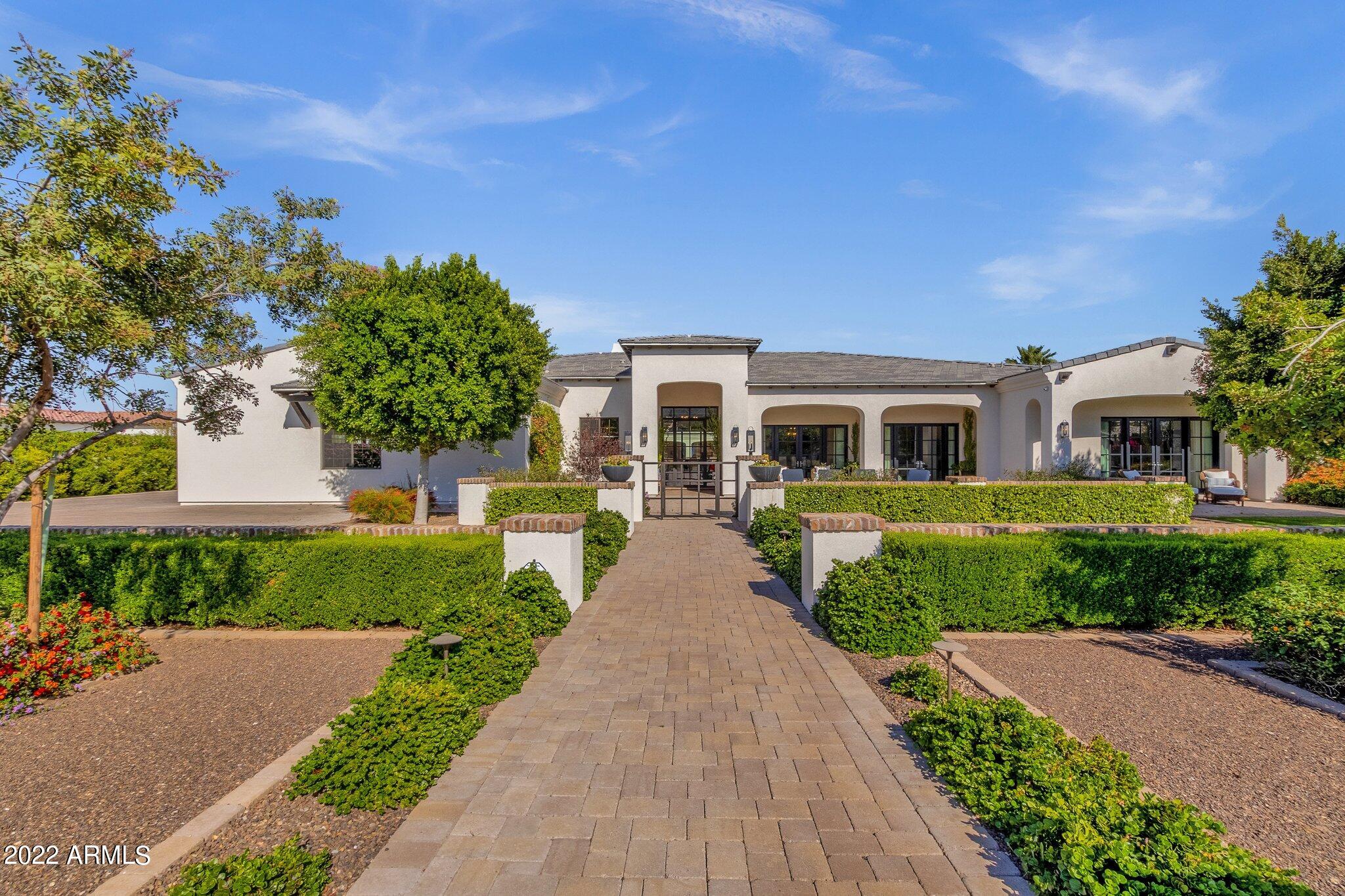 THIS STUNNING SINGLE-LEVEL CUSTOM HOME IS IN THE HIGHLY DESIRED ARCADIA VISTA MANOR WITH AN OPEN SPLIT ROOM FLOOR PLAN AND SOARING CEILINGS!  HOME BOASTS 5 BEDROOMS AND 5.5 BATHROOMS WITH 6,618 SF OF LUXURIOUS LIVING SPACE.  THE INSIDE FEATURES A GLASS DOOR ENTRY/FOYER WITH BRICK CEILING ACCENT AND WOOD FLOORING THROUGHOUT THE MAIN LIVING AREAS OF THE HOME.  ATTENTION TO FINEST DETAILS ARE NOTATED EVERYWHERE, WITH EXPERT CRAFTMANSHIP FROM THE BUILDER. GOURMET KITCHEN HAS AN OVERSIZED CENTER ISLAND WITH QUARTZ SLAB COUNTERS, EAT-UP SEATING AND PENDANT LIGHTING, SUB-ZERO WOLF AND ASKO APPLIANCES, DOUBLE OVENS, 6-BURNER GAS RANGE, AND A BREAKFAST NOOK WITH VIEWS TO THE LUSH BACKYARD.  THE MASTER SUITE HAS BEAMED WOOD CEILINGS, SEPARATE HIS/HER WALK-IN CLOSETS AND PATIO DOORS TO THE BACKYARD. ALL BEDROOMS HAVE THEIR OWN EN-SUITE BATHS.  OUTSIDE YOU'LL FIND A RESORT-STYLE BACKYARD COMPLETE FOR ENJOYING THE GREAT ARIZONA WEATHER!  PEBBLE-TEC POOL AND RAISED SPA WITH WATER FEATURES ALONG WITH TRAVERTINE SURROUND DECKING, A COVERED CABANA WITH BUILT-IN WET BAR THAT HAS MULTIPLE FRIDGES, SINK, AND PREP AREA.  BUILT-IN FIREPLACE ARE WITH SEATING AS WELL AS A SEPARATE DINING AREA. A SPORTS COURT COMPLETE WITH TENNIS AND PICKLEBALL COURTS AND BASKETBALL HOOPS.  THIS HOME IS TRULY AN ENTERTAINER'S PARADISE!