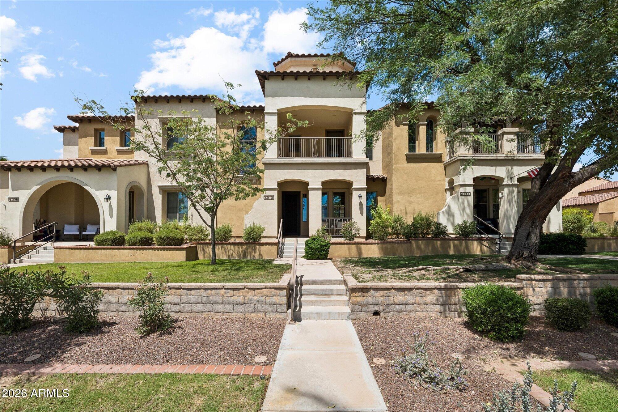 Welcome to Verrado! Perfectly positioned in the heart of the Main Street district, this charming townhome has golfing, restaurants, coffee shops & everyday conveniences just steps from your front door. Start your mornings on the front porch with a cup of coffee. Freshly painted inside & with brand-new carpet throughout, creating a move-in ready space that feels crisp and inviting. The downstairs primary suite offers a peaceful retreat complete with dual sinks, soaking tub, separate shower and walk-in closet. Upstairs, the secondary bedroom enjoys private access to a full bath, the versatile loft opens to its own balcony overlooking Marketplace. The cozy courtyard is beautifully designed, featuring a covered patio, stunning travertine and a gas firepit - perfect for those cooler AZ nights!