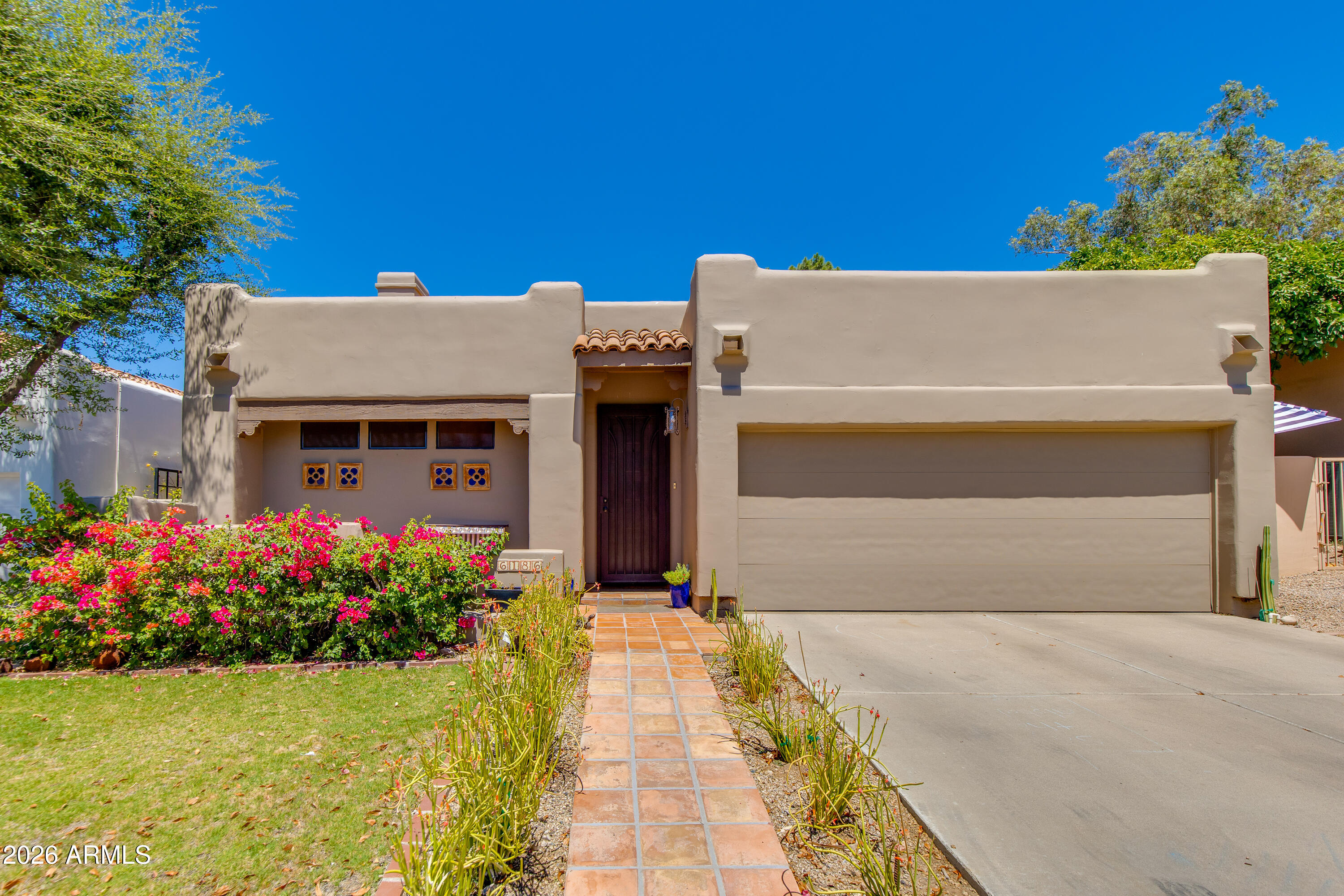 Golf course home in the gated Biltmore Villas II community. This home features vaulted ceilings, Saltillo tile floors, a spacious great room, open kitchen, and dual primary suites. Enjoy outdoor living from the covered patio overlooking the 14th hole of the Arizona Biltmore Links Course, with views of Piestewa Peak and low-maintenance desert landscaping. Conveniently located near the iconic Arizona Biltmore Hotel, Biltmore Fashion Park, dining, hiking, golf, and all that the Biltmore area has to offer.