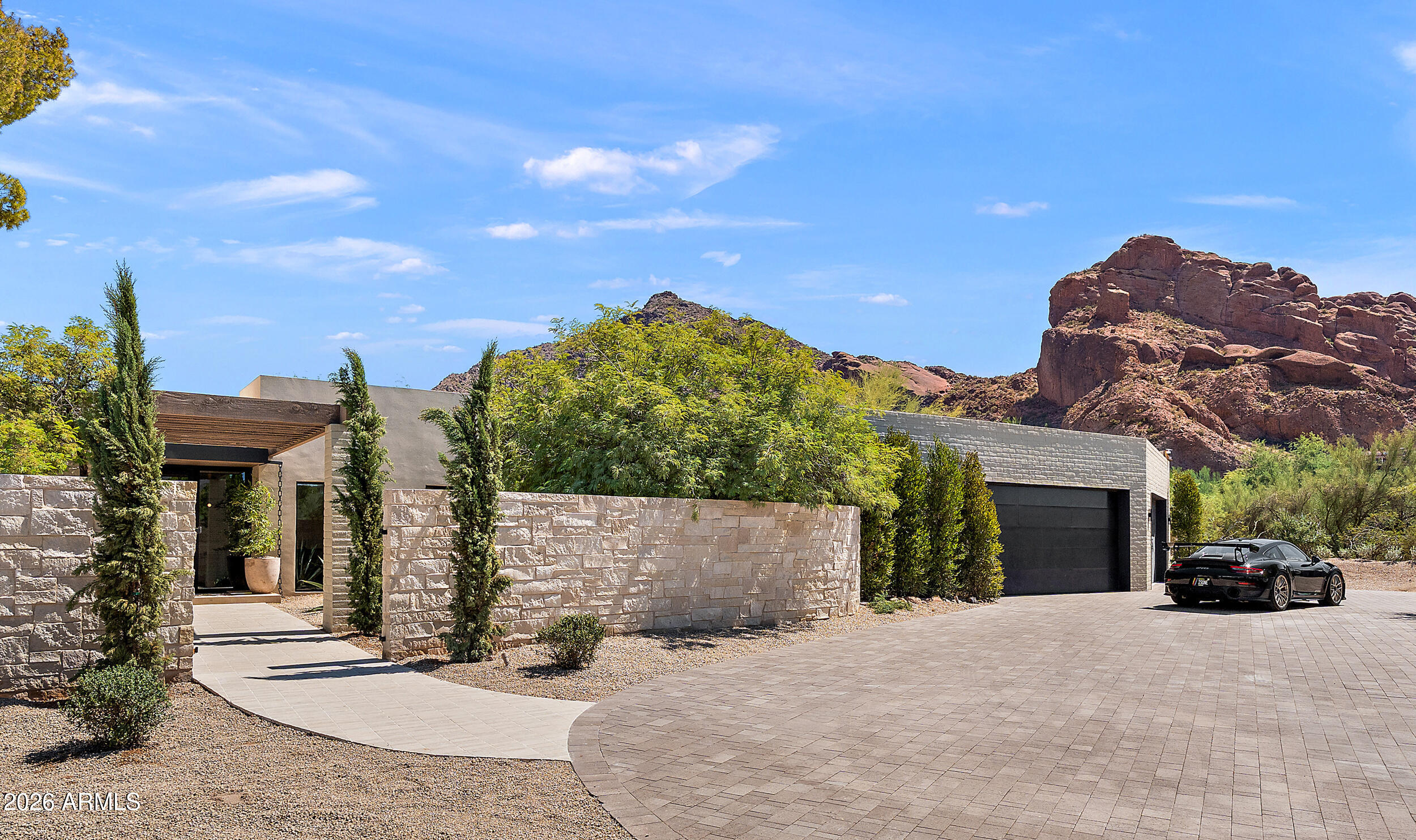 Designed by PHX Architecture, this extraordinary new-build is a striking expression of desert modern luxury, where sophisticated design meets breathtaking natural beauty. Walls of glass frame majestic mountain vistas, while skylights bathe the interiors in soft, natural light throughout the day. A rare fusion of mid-century desert influence and contemporary refinement, this true custom estate showcases impeccable craftsmanship and elevated finishes at every turn.
Perfectly positioned in one of Paradise Valley's most coveted enclaves--just one block from iconic Camelback Mountain--the property spans approximately 7,170 square feet across the main residence and guest house, offering a seamless blend of privacy, scale, and sophistication.