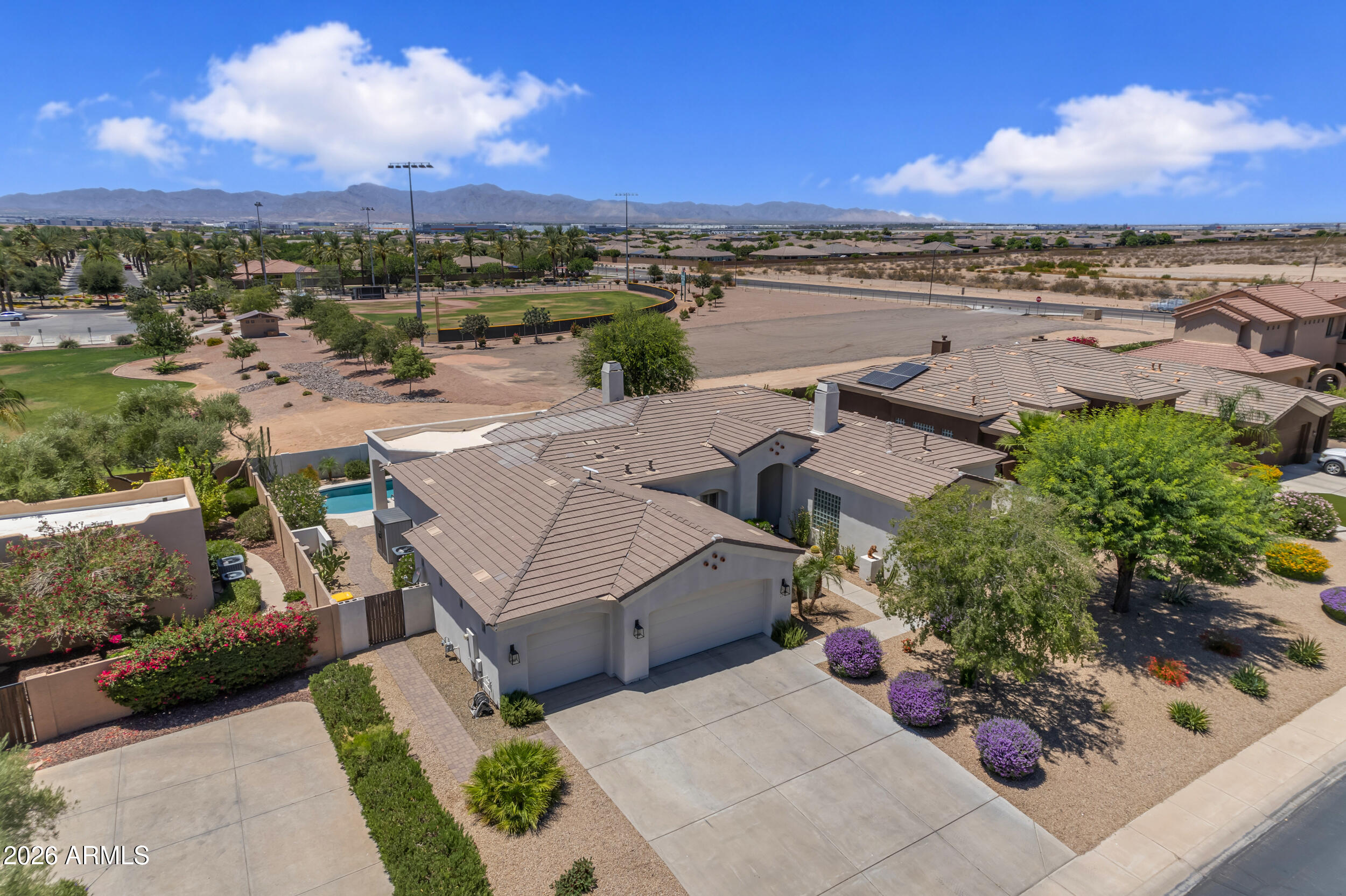 Nestled in the prestigious, gated community of Litchfield Greens, this breathtaking 2,715-square-foot estate exemplifies desert luxury and meticulous care. From
the moment you step inside, you are greeted by soaring ceilings, abundant natural light, and new ceramic wood-look tile flooring that flows seamlessly through
the formal dining room, separate living room and open great room, with ceiling fans installed throughout for optimal year-round comfort. The gourmet kitchen is
a chef's dream, featuring freshly painted staggered white cabinets, premium granite countertops with a stunning tile backsplash, a classic farmhouse sink, a
central island, a breakfast nook, and top-tier, newer matching KitchenAid appliances complete with a gas cooktop. Elegant wood shutters throughout the home ad Elegant wood shutters throughout the home add a timeless touch of sophistication, leading you to the private master split retreat, which boasts a spacious en-suite bath with a relaxing jacuzzi tub. Along with the 3 large bedrooms and 2.5 bathrooms, the home includes a spacious den with a separate entrance, perfect for a home office, guest suite, or studio.
Step outside into your private, 11,627-square-foot sanctuary, where you will enjoy complete privacy with no neighbors behind you. The expansive backyard is a rare desert find, offering lush landscaping with real grass and thriving lemon, lime, and orange trees for fresh citrus. Entertainment options abound with a cozy gas firepit and a sparkling pool that was recently refreshed with new decking and pristine Pebble Tech finish, making it the ultimate spot to take in the breathtaking Arizona sunsets and majestic mountain views. Major high-ticket upgrades provide ultimate peace of mind, including a new roof installed in 2021, fresh exterior and interior paint, and an extended 3-car garage outfitted with brand-new epoxy flooring. This turn-key masterpiece perfectly combines a luxurious, private lifestyle with an enviable location just moments away from the legendary Wigwam Resort golf courses.