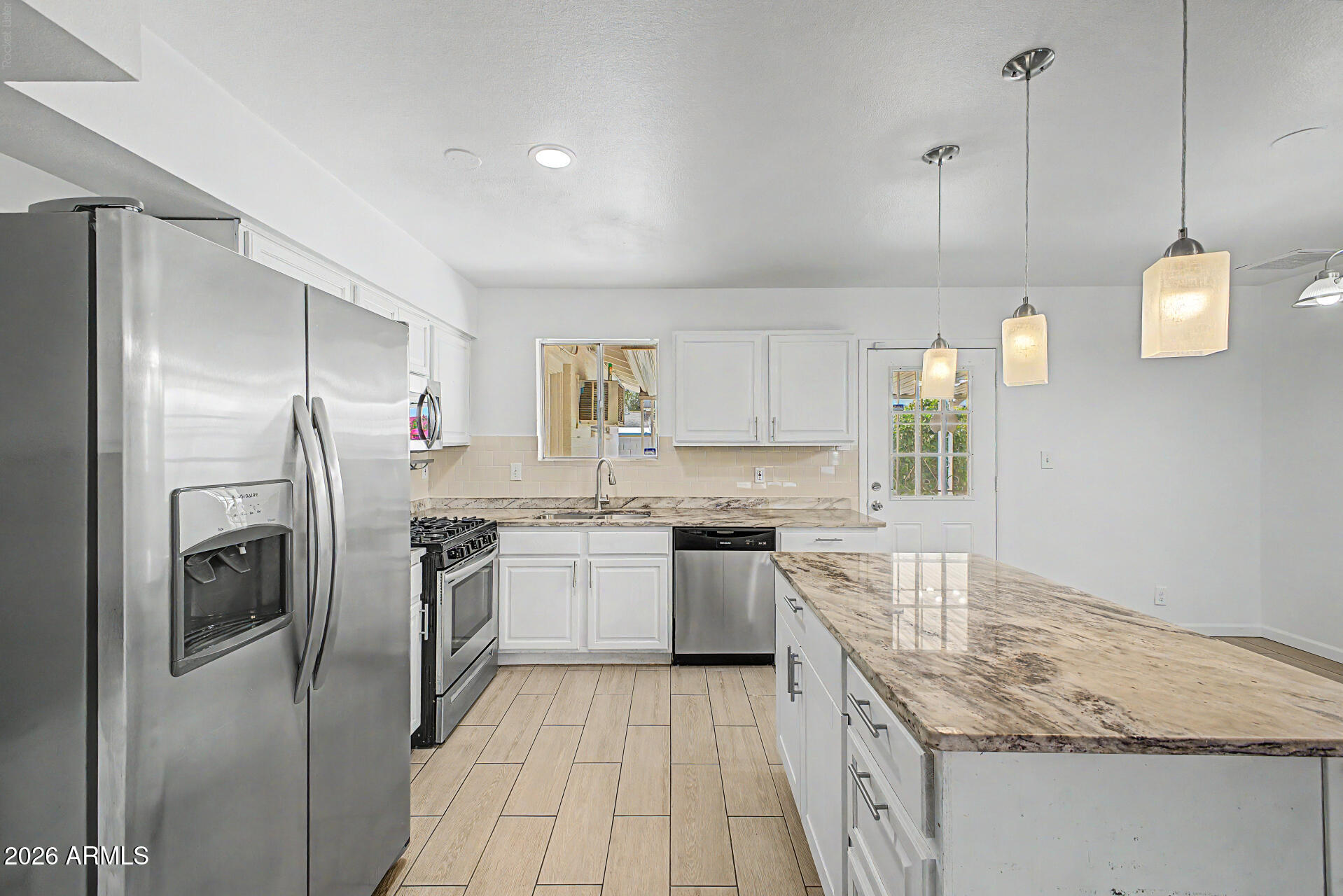 This 4bd, 2ba home perfectly situated in North Phoenix offers the freedom of no HOA, and a spacious backyard complete with an RV gate and paved parking area for your RV, boat, or other toys! Inside, you'll find an inviting open-concept floor plan featuring a recently updated kitchen with granite countertops, stainless-steel appliances, and a freshly painted interior. The oversized primary suite provides direct access to the covered back patio, creating the perfect indoor-outdoor living experience. Major updates include a recently replaced roof and air-conditioning system, providing added value and peace of mind. Conveniently located near shopping, dining, restaurants, schools, parks, and major freeways, this home combine comfort, convenience, and versatility in one desirable package.
