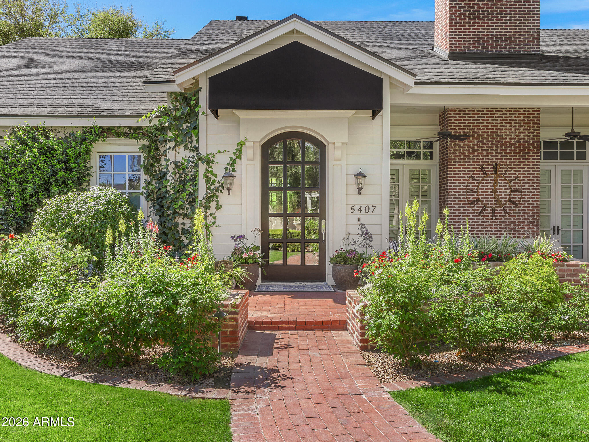 This stunning Cape Cod-inspired Arcadia residence blends timeless charm with thoughtful modern updates, set on a lush, oversized lot along a quiet, picturesque street. Light-filled interiors feature soaring ceilings, clerestory windows, and multiple French doors that create a seamless connection to the outdoors. The spectacular great room is anchored by an exquisite chef's kitchen, complemented by three fireplaces, wide plank wood flooring, beautiful millwork, and refined finishes throughout.  The home offers five bedrooms plus a versatile flex room or office, along with a truly stunning primary suite designed for comfort and elegance. Recent enhancements include a new roof, a sparkling new pool, a newly built outdoor kitchen, and a beautifully designed ramada, creating an elevated indoor- -outdoor lifestyle.  The backyard is a private retreat, complete with mature landscaping, a water feature, fire pit, and inviting spaces for dining and entertaining. An oversized three car side-entry garage and expansive laundry room add to the home's practicality.  Located just moments from Hopi Elementary and featured in national commercials for its warmth and classic appeal, this exceptional home captures the essence of Arcadia living at its finest.