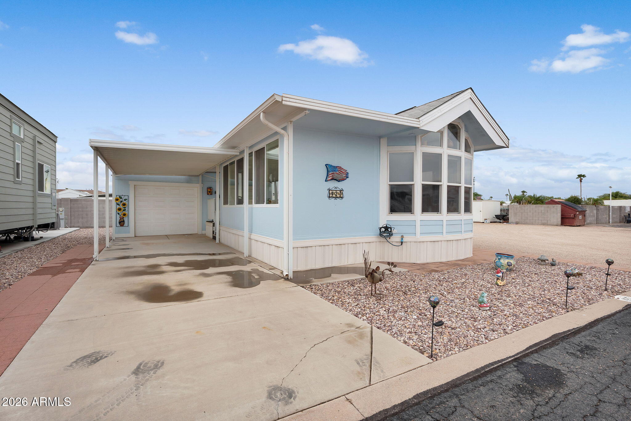 Welcome to your fully furnished 1 bed, 1 bath retreat in Tierra Del Sol RV Resort, where you own the land (no land lease)! This charming home features vaulted ceilings and tons of windows that flood the space with natural light, plus mechanical sunshades for comfort and privacy. The updated kitchen includes all appliances, and stylish wood-look vinyl flooring was installed in 2021. Enjoy extra living space in the permitted Arizona room, and store all your gear in the detached garage. Situated on a large corner lot just steps from the pool and clubhouse, this move-in ready gem offers resort-style living year-round!