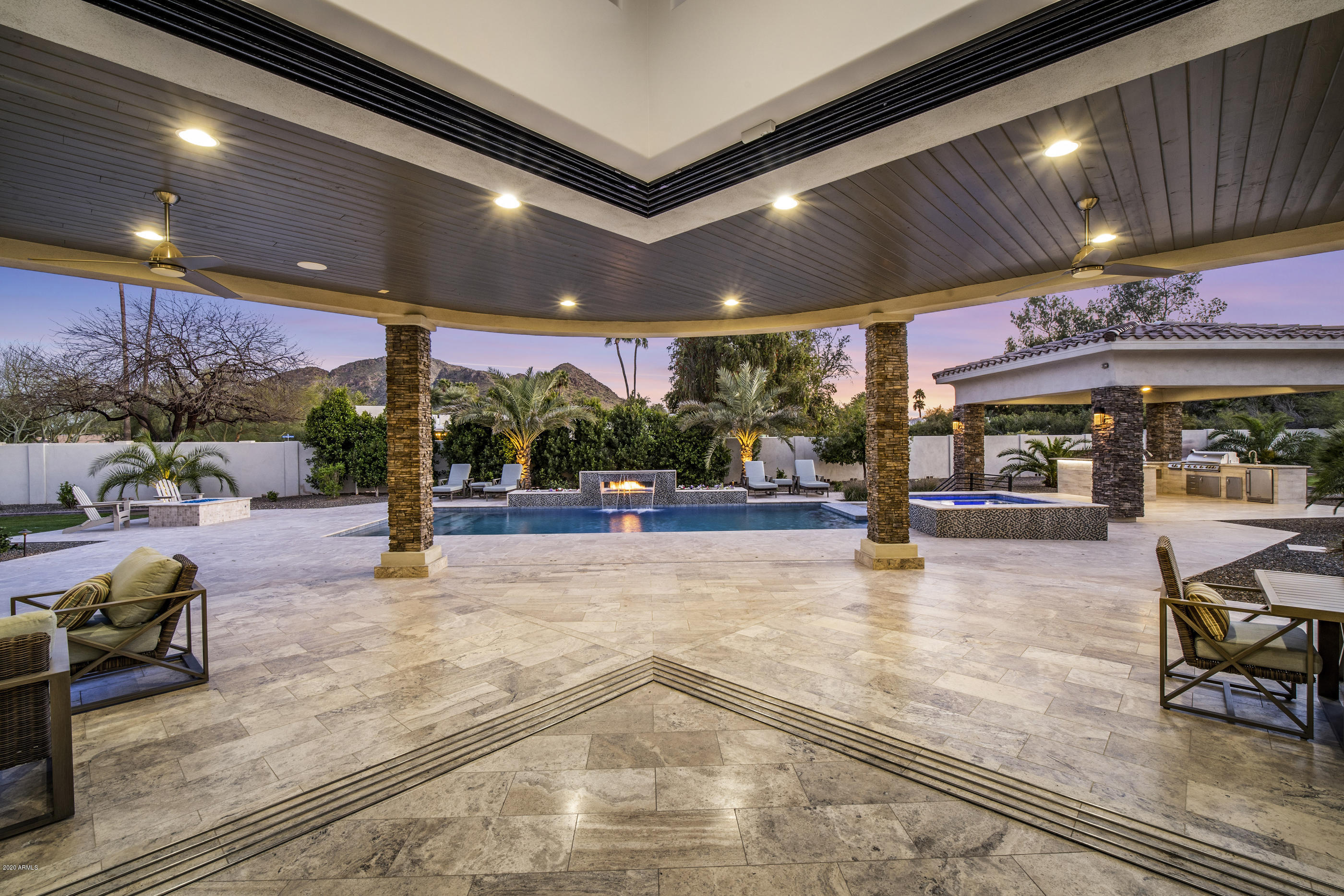 Beautiful and warm contemporary living at its finest. Located in the heart of Paradise Valley with incredible views! Indoor/outdoor living with ease with magnificent wall of glass doors opening to a resort style backyard with Pool, heated spa, swim up bar at the Ramada including built in bbq, refrigerator and sink.  Enjoy your evenings at the pool with the sheer decent and fire feature at the pool.  In the morning your coffess will be even better gazing at the mountain views. Extra spacious kitchen with two large islands. a walk in wine room, bar and media room. Be certain to enjoy the video. This elegant home is must see...come visit today!