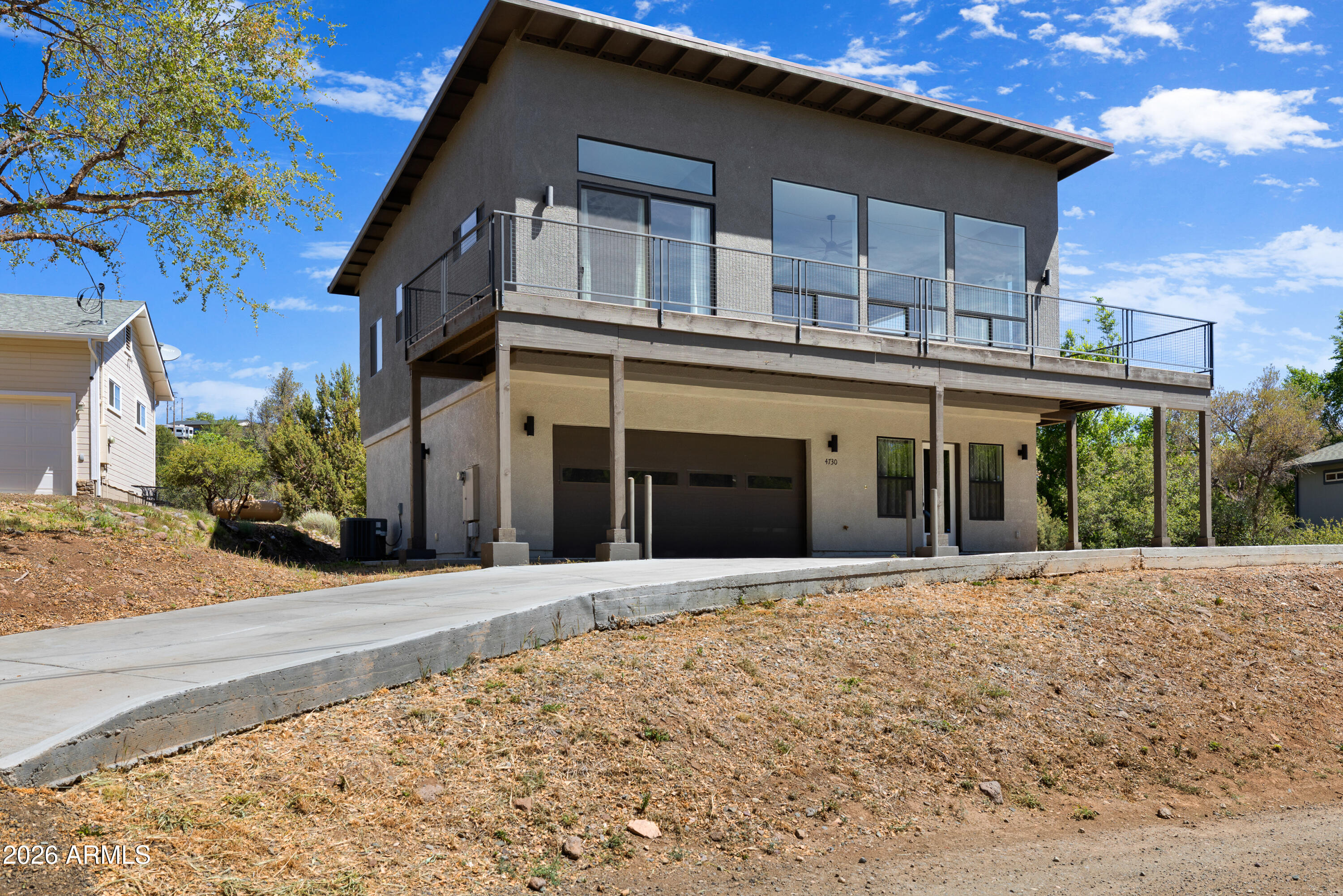 Modern three-bedroom, three-bathroom home located in Prescott's Diamond Valley neighborhood. with no HOA. This property offers a quiet country setting while remaining just minutes away from local shopping, dining, and entertainment.
The home features an open floor plan with high-quality finishes throughout. On the upper level, the spacious great room includes vaulted ceilings and large windows that provide beautiful views of the mountains and surrounding countryside. The kitchen and dining area are equipped with modern shaker-style cabinetry, granite countertops, luxury vinyl plank flooring, and a peninsula designed for entertaining. Additionally, the interior is finished with LED lighting and raised panel doors, while the outdoor space features an expansive composite deck with contemporary railings perfect for relaxing and enjoying the wonderful views.