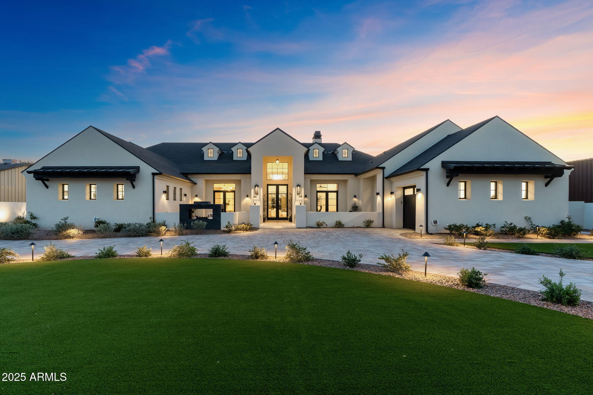A home for those who understand the assignment. Located on a full acre in Scottsdale's coveted Cactus Corridor, this estate is fully furnished with a curated selection of mostly Restoration Hardware pieces, delivering a consistent, elevated design language throughout. Completed in 2023 and recently enhanced with high-end finishes, the home blends modern architecture with understated luxury. The interior palette is clean and sophisticated, exuding an earthy luxe ambiance that blends natural warmth with elevated design. With wide-plank white oak flooring, natural stone surfaces, custom cabinetry and designer lighting, each space is defined. The kitchen is anchored by a massive central island and supported by a sleek back kitchen for additional prep and storage. Floor-to-ceiling glass creates a seamless connection to the outdoors allowing the home to feel both expansive and grounded. 6 ensuite bedrooms, multiple living areas and a separate lounge offer versatility without sacrificing flow. The primary suite is privately positioned and designed as a true retreat, featuring a separate sitting room, dual closets, a spa-style tub, and its own dedicated washer and dryer.
Functionality meets design in the oversized laundry room and drop zone just off the garage, outfitted with custom cabinetry, ample storage and a built-in dog wash with handcrafted Zellige tile. Every detail was considered, blending everyday practicality with designer-level execution. This property also includes an attached guest casita with its own private entrance and garage, multiple main garages with capacity for up to 15 vehicles, including an RV-height bay currently repurposed as an indoor play area for basketball and soccer, offering exceptional flexibility for families or collectors.
Outside, the landscaping is equally intentional. Mature ficus line the perimeter for privacy, while towering palms and layered landscaping add structure and scale. A clean-lined pool, elevated spa, outdoor kitchen and multiple lounge areas complete the setting. Every material and finish was selected for both beauty and cohesion, creating a home that feels as thoughtful as it is luxury.
Privately gated, fully automated and offered turn-key, this is one of the most refined and design-forward residences in the Cactus Corridor!