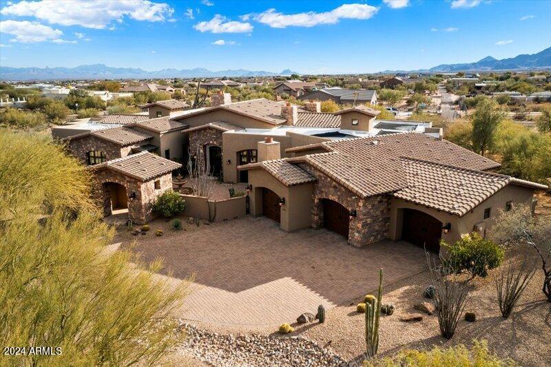 Spectacular luxury living in this meticulously designed Spanish Ranch home, nestled in Granite Mountain Ranch, North Scottsdale's only gated equestrian estates. Gorgeous Four Peaks mountain view estate is on almost 5 acres (2 lots) located at the end of a large cul-de-sac. Sale includes two parcels totaling 4.803 acres - parcels 219-40-083 and 219-40-082.The property's circular driveway and stone gate house create a grand entrance with a fountain and gas fireplace that welcomes guests with a sense of luxury and prestige.  An architectural masterpiece, this four-bedroom custom home with attached casita was originally crafted for the architect himself, and exudes sophistication and attention to detail at every turn. The interior is captivating with elegance and warmth, and has four distinct shapes of large tumbled travertine, laid in a Versailles pattern throughout main living areas and extending gracefully to the outdoors. Pillars and niches adorned with ambient lighting create a timeless look.  Main living area has amazing views to the outdoors with a massive cantera stone gas fireplace.

The kitchen is a chef's delight, equipped with a warming drawer, appliance garage, a new ASKO dishwasher and a huge center island with granite slab countertops. The Wolf built-in cooktop and oven are propane gas and the range hood is accentuated with faux painting. The SubZero double refrigerator and two dishwashers ensure efficiency. The separate bar seats five and is granite-topped with ice maker and wine chiller.

This residence is a showcase of thoughtful features, including a central vacuum system, four AC zones, an AV closet and a beautiful powder room. The den, complete with wood-beamed ceilings offers versatility with its closet, potentially transforming it into a bedroom. A four-car garage with epoxy floors and a spacious in-garage storage room. The utility closets house a water softener, 4 HVAC air handlers, and two hot water heaters.

The primary suite on the same side as the den invites tranquility, with wood flooring, knotty alder cabinets and doors, and a gas fireplace. The primary bath is a spa-like retreat, featuring a coffee bar with built-in SubZero refrigerator, jetted soaking tub, separate closets with custom built-ins, and an indulgent six-shower head experience. Enjoy the breathtaking view of Four Peaks from the primary bathroom, complemented by a travertine outdoor shower.
Your visitors will love the guest amenities, with two spacious guest suites on the opposite side of home with private baths and large walk-in closets. A 400 sq ft casita with a kitchenette, SubZero fridge, walk-in closet, and full bathroom provides your guests a private retreat.

Technology seamlessly integrates with luxury in this property, with Control 4 system, managing 4 outdoor security cameras, music with in-ceiling speakers throughout the house and back patio, weather, and six mounted TVs which convey to the buyer. A formal dining room with a bricked ceiling and double doors opening to the front courtyard sets the stage for intimate gatherings around the gas fireplace and courtyard fountain.

The outdoor space is an entertainer's dream. The backyard oasis offers unobstructed Four Peaks and Matzatzal mountain views, with a Jacuzzi and pool that can be controlled from inside the home. Owned solar system heats the pool for extended enjoyment in the fall and spring. A built-in grill and bar, wood-burning fireplace and firepit complete the entertainment amenities.

Granite Mountain Ranch is the only gated equestrian community in Scottsdale where each homeowner can have up to 4 horses per lot. It has 100 home sites spread across 315 acres, 15 acres of equestrian facilities including 2 large arenas and 2 round pens, paved and lighted streets, underground utilities and a private water resource. It's adjacent to the McDowell Sonoran Preserve. You'll have easy access to unlimited riding trails, hiking, biking & fishing. Within a 10-to-30 minute drive are many of Arizona's top golf courses.