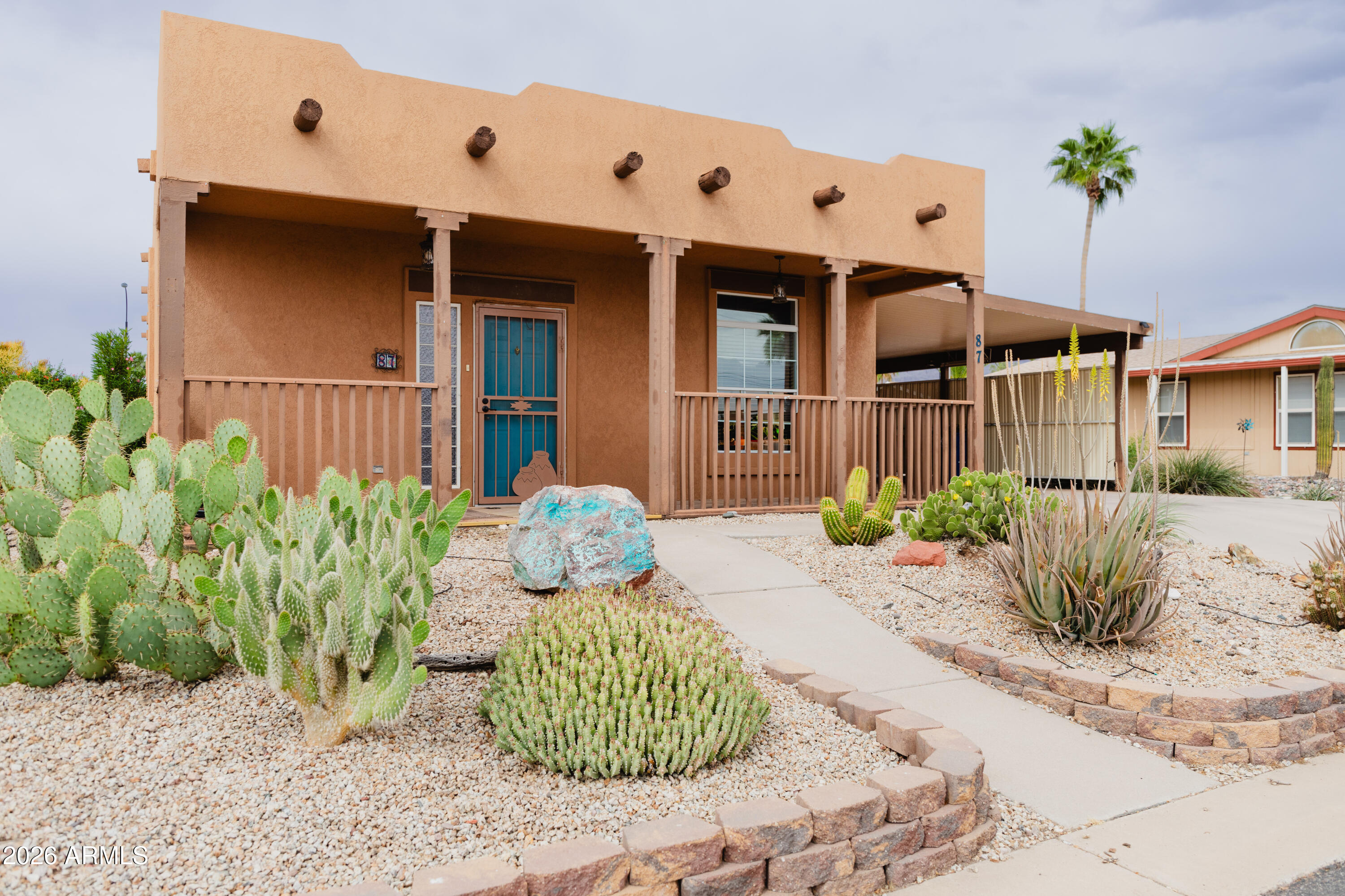 Step into this charming and spacious 3-bedroom with rare Adobe Santa Fe exterior. Feel right at home and stay cool with an upgraded Trane A/C. Home features partial wood look tile, kitchen with an island, tons of cabinetry and pull-out drawers. Large primary bedroom with walk in closet. Enjoy whole-home purified water and relax in the screened-in Arizona room. The backyard includes a half wall for added privacy, a storage shed, and lush flowering shrubs and trees. Located in a vibrant 55+ community with abundant amenities, this home blends comfort, style, and lifestyle perfectly. Don't miss #87!