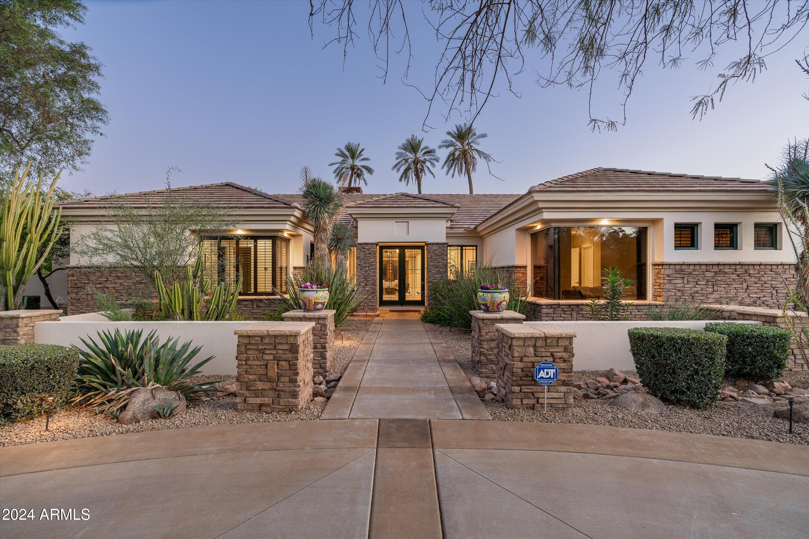 Experience elegance in this custom-built 5 bedroom all en-suite, 7-bath luxury estate. Bonus room (could be 6th bedroom) and a large Game Room! Home is craftsman-inspired where warmth meets refined sophistication. Nestled to capture breathtaking mountain views with a South backyard, this home's sprawling grassy backyard and mature trees is an entertainer's paradise, featuring a resort-style retreat with a sparkling spa, lap pool, sport court, and an expansive covered patio perfect for outdoor living and dining. Inside, the split floor plan offers four ensuite bedrooms, each with custom walk-in closets, plus a built-in study area for added versatility. The Primary Suite was recently updated with timeless wood floors, walnut millwork, a luxurious bath featuring a Dry Sauna, Spa-Style dual shower, custom floating walnut vanities and gorgeous lighting!  Closet to be envied and a large center island. An attached exercise room is the added bonus to this suite. 
 An attached casita provides the perfect setting for a playroom or guest suite, while a secluded office, located near the walk-in wine room, offers an elegant, private workspace. Practical elegance is found in the well-appointed laundry/workspace, mudroom, and storage area adjacent to the garage. Don't miss the wine cellar room and spacious garage with even more storage. Enveloped by mature landscaping, this estate offers total privacy and captures the beauty of its mountain surroundings, creating an exquisite luxury retreat. Located in the heart of Paradise Valley and walking distance to Cherokee Elementary School.