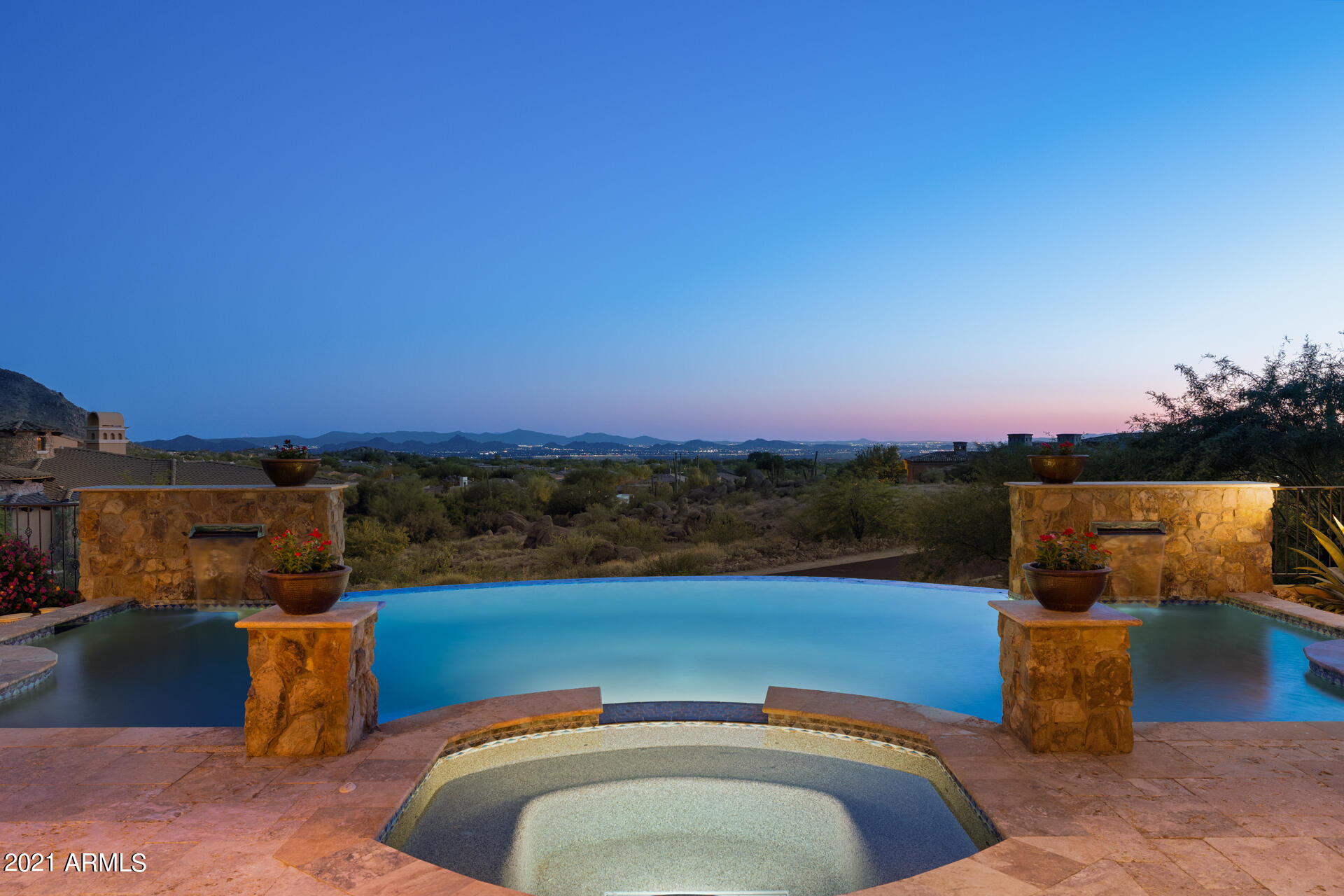 This custom home has SHOW STOPPING views of the valley! The pocket doors in the living room allow for an incredible indoor/outdoor space overlooking the pool & hot tub. Cooking in the chef's kitchen makes life easy-gas cooktop, 2 refrigerators, walk-in pantry & giant island. The impressive master suite has it all! His & hers closets, soaking tub, sitting room, fitness room (all with views), urinal & a sauna along with french doors to the patio. Each en-suite bedroom offers a walk-in closet, patio & views of Pinnacle Peak. There are 2 attached guest houses both with access to the garage & private entrances. The grounds are grand too! With a rooftop deck, 2 gas fire-pits, an outdoor BBQ & half bath for the pool, you are ready to entertain & take in the breathtaking Arizona sunsets!