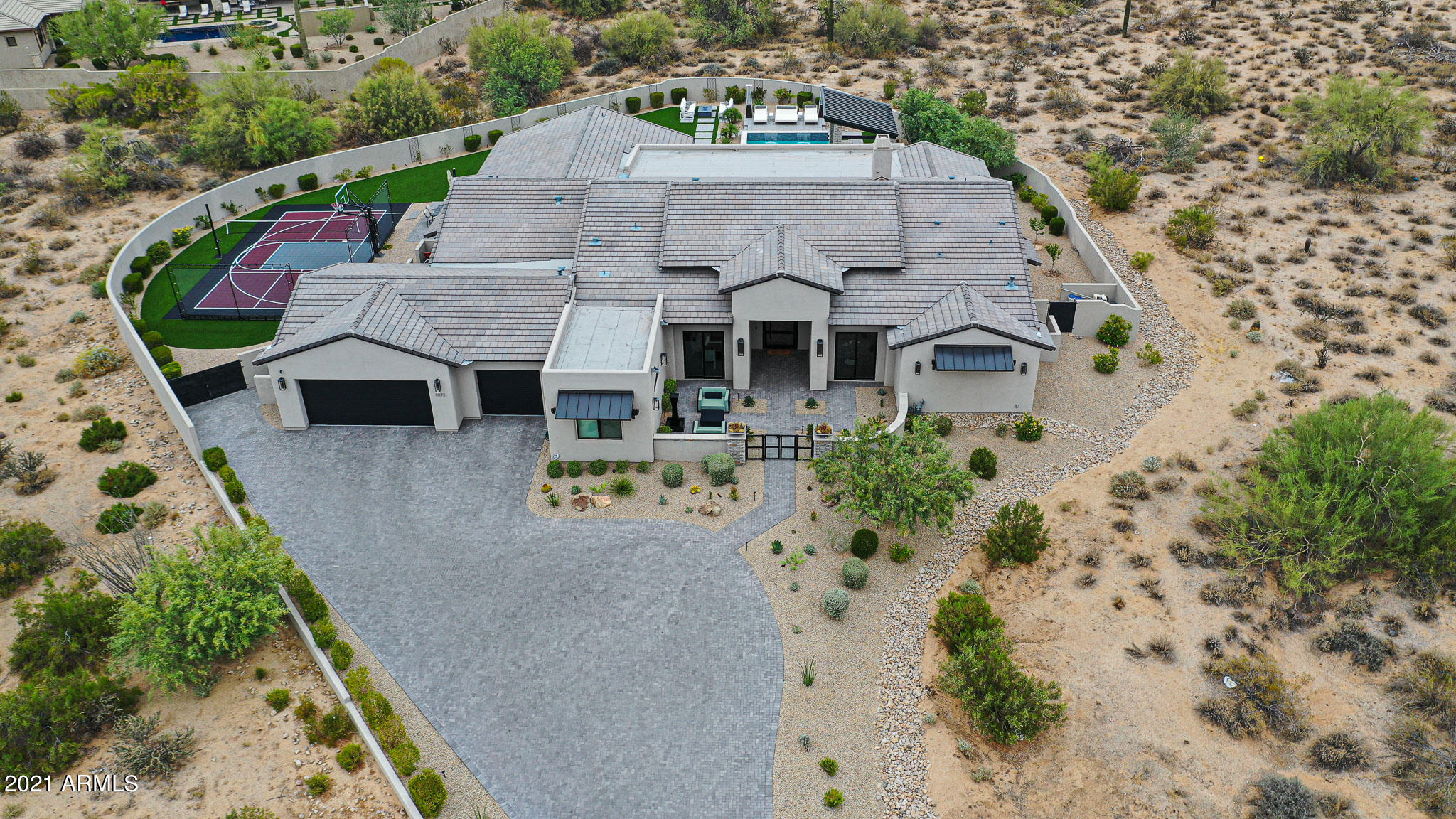 Welcome to this North Scottsdale show stopper!! Follow the perfectly landscaped and equally dramatic driveway to your 10 foot custom Iron front door! Upon arrival, the wide open great room is framed by a stunning oversized gourmet kitchen featuring Italian White French Quartzite, Wolf and Subzero Appliances. This spectacular open concept floor-plan features gorgeous site lines and the perfect combination of form and function. Over 5,000 sqft without an inch of wasted space that has the perfect flow for both family and entertaining. The oversized master bedroom features spectacular views, spa like bath, and a closet to die for with its own washer/dryer! Off the master is a stunning powder room and a private office overlooking the front courtyard. The other side of the home features 3 additional en-suite bedrooms and a state of the art movie theater that also has a full bath! Back in the heart of the home is a 16 foot pocket door that creates the ultimate indoor/outdoor feel to your resort style backyard! And outside is where the real fun begins; a huge covered patio, sparkling pool/spa, ramada with fireplace, full outdoor kitchen, 3,000 square feet of turf, and a sports court round out this outdoor oasis! Located in one of North Scottsdale's finest gated communities surrounded by stunning views and world class, hiking, dining, and so much more! This one won't last long!