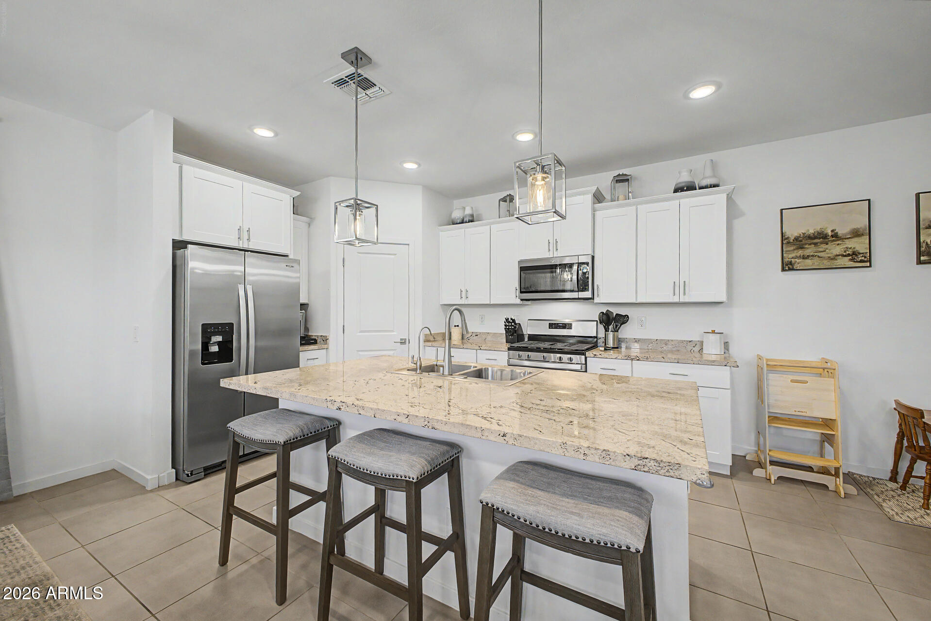 Better than a new build--this 4-bedroom, 2-bath home in Hurley Ranch already has the upgrades done for you, including a FULLY finished backyard with beautiful grass and laid pavers. The inviting interior showcases abundant natural light, a neutral palette, recessed and pendant lighting, tile flooring in the common areas, and Berber carpet in the bedrooms. The impeccable kitchen boasts upgraded stainless steel appliances, granite countertops, a large pantry, white shaker cabinets, and an island with a breakfast bar. Enjoy added convenience with a water softener and reverse osmosis system, helping protect against Arizona's hard water. Designed for everyday living and entertaining, the seamlessly flowing open layout is sure to impress. The spacious primary bedroom features an ensuite with dual sinks and a walk-in closet. Don't miss this excellent opportunity!