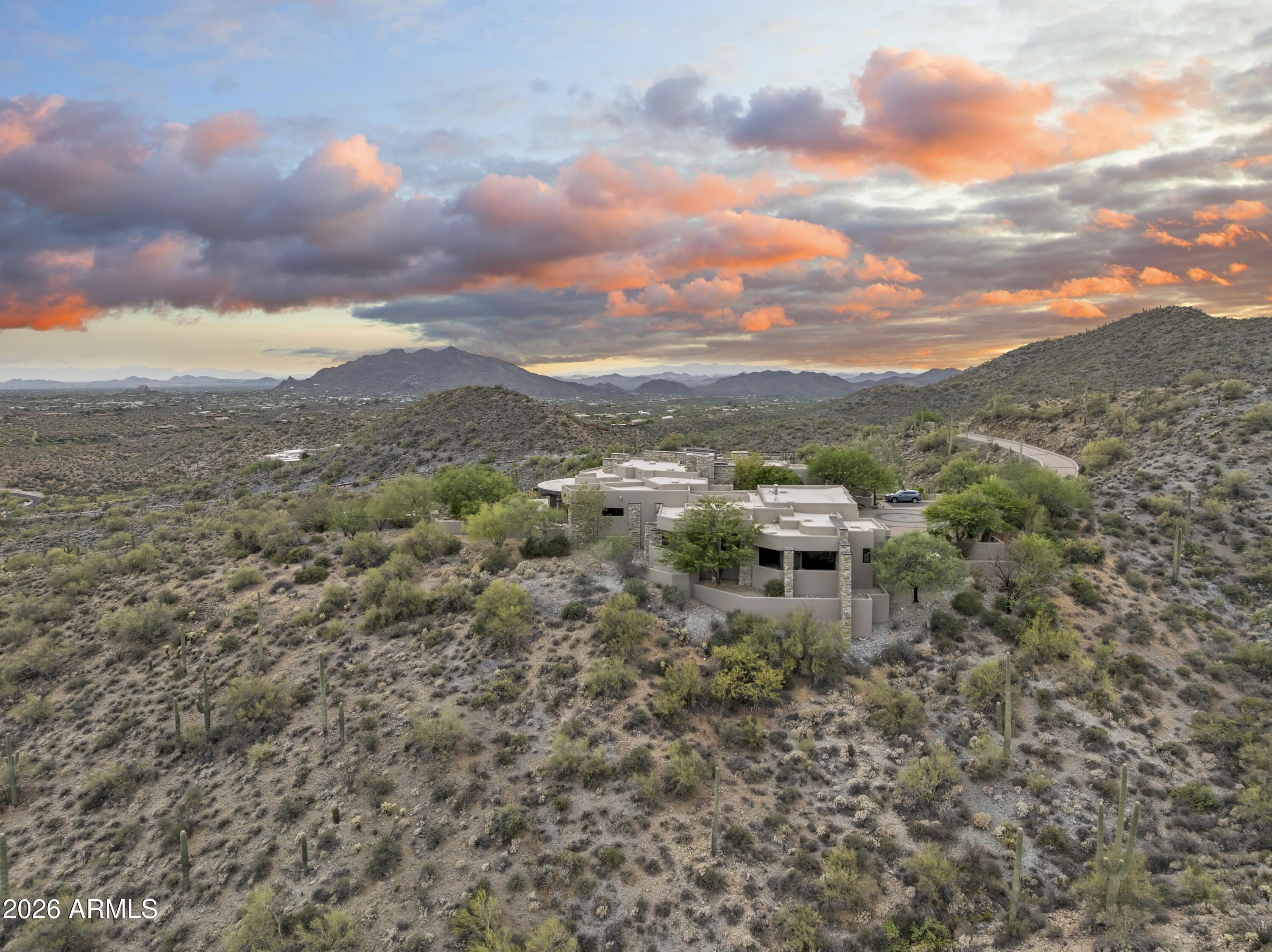 Sprawling 24.5-acre Guard Gated mountaintop estate within Carefree Ranch Homesteads occupies a rare south-facing peninsula-like ridge where architecture, privacy, and desert grandeur converge. A private gate and descending drive lead to a large motor court, creating a dramatic sense of arrival. The residence is positioned to command uninterrupted panoramas of city lights, layered mountain silhouettes, and Arizona's spectacular sunrises and sunsets. Designed for those who value quality and seclusion, the home is a study in elevated desert living, including thoughtful indoor-outdoor connections, and top-tier amenities which enhance the natural drama of the site. Every detail, from the approach to the living spaces to the expansive view corridors, has been composed to celebrate scale... , serenity, and the art of living. Exceptional in its setting and rare in its offering, this estate delivers a level of privacy, presence, and visual impact seldom found at this price point. A true mountaintop sanctuary, inviting a lifestyle defined by quiet luxury architectural distinction, and sweeping views that feel entirely your own.