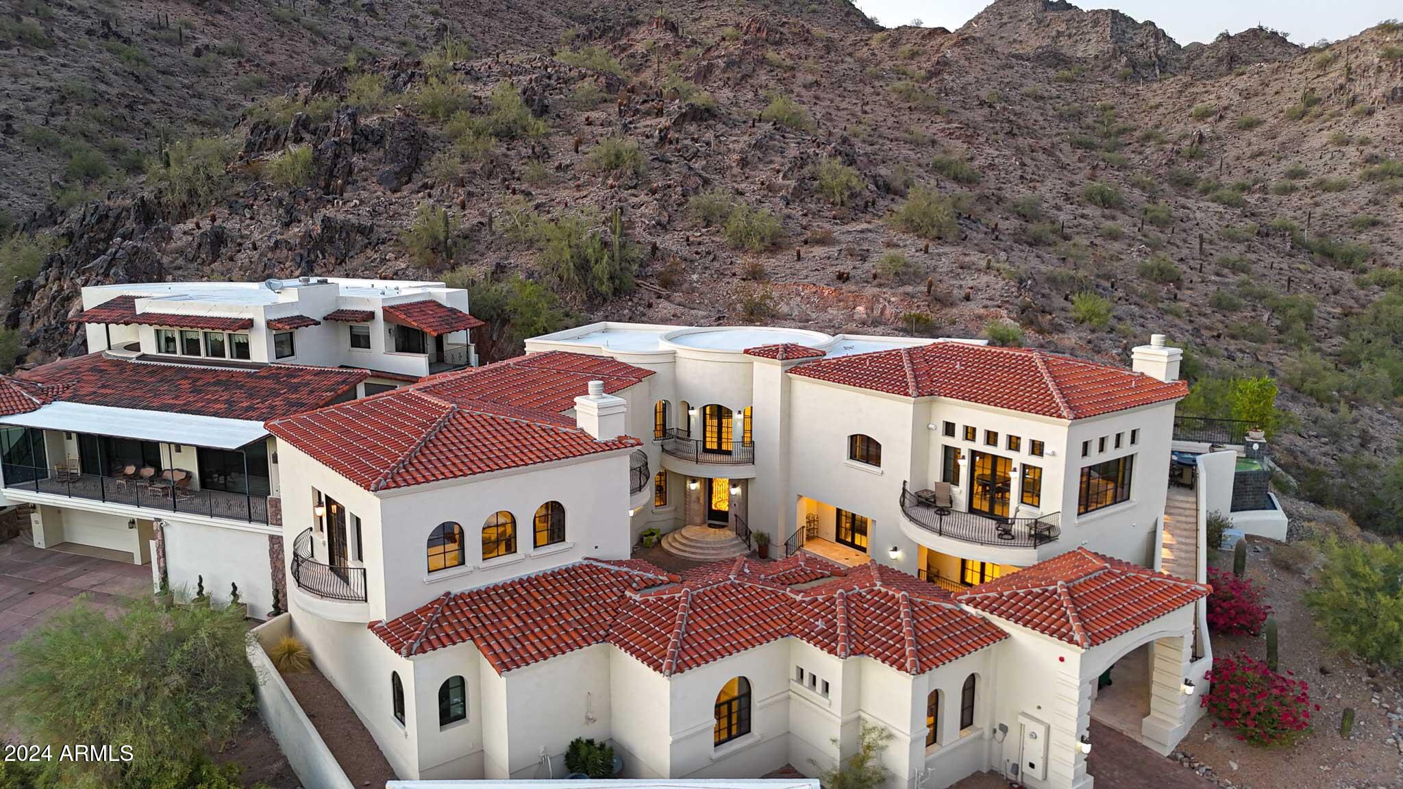 Exquisitely custom built Mediterranean hillside home nestled at the top of guard gated ''Estate Antigua'' in the Phoenix Mountain Preserve with unparalleled panoramic mountain & city light views! Cut into the mountain rock, and 1 of only 4 custom homes, this home features the highest elevation offering million dollar unobstructed majestic views of the Phoenix Mountain Preserve behind, to the sweeping valley views including uptown & downtown Phoenix in front. Located in the foothills next to Paradise Valley, you will feel like you've escaped to Sedona while being only minutes away from Scottsdale Fashion Square Mall, Old Town, and the Biltmore area... where you'll find world class shopping and countless restaurants of all gourmet levels. Whether you prefer a morning cup of coffee while coffee watching the sunrise over the mountains or an ice tea relaxing in the infinity edge spool at sunset, you'll find that you can't wait to get home after a long day at work. There is only one concern - once you are home, you'll never want to leave!