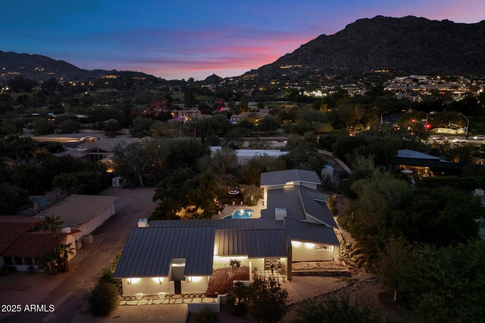 Tucked away in a peaceful pocket of Paradise Valley, this Modern sanctuary—completely transformed and finished in 2025—showcases sweeping vistas of Camelback, Mummy Mountain, and the Phoenix Mountain Preserve. The result of a meticulous four-year redesign, the home blends thoughtful craftsmanship with refined everyday comfort. Across its 4,131 sq ft, the 4-bedroom, 4-bath floor plan features soaring ceilings, expansive glass walls, and a striking floating staircase that defines the main living area. The kitchen is both sculptural and functional, outfitted with Poggenpohl motorized cabinetry, integrated Miele appliances, an oversized island, and a concealed automated pantry for effortless organization. The primary suite serves as a private haven, highlighted by a cozy fireplace and a resort-level bath with rain and cascade shower experiences, blue stone vessel sinks, double vanities, Rubinetterie Treemme fixtures, and a Toto Neorest. Two main-level en-suite bedrooms provide comfort and convenience, while a fourth suite upstairs opens to a view terrace overlooking the poolan ideal setting for guests or a dedicated office. Behind the beauty, the home has been completely rebuilt with new electrical, plumbing, and gas systems, an upgraded 1½" water meter, dual HVAC units, whole-home water filtration, and a 10-camera security system. A fully permitted four-car garage also allows for future rooftop deck possibilities, adding versatility and long-term appeal. Enveloped by mature landscaping and framed with teakwood pool decking, this property offers exceptional privacy and uninterrupted mountain panoramasall just minutes from Camelback Inn, Mountain Shadows, and The Sanctuary.
