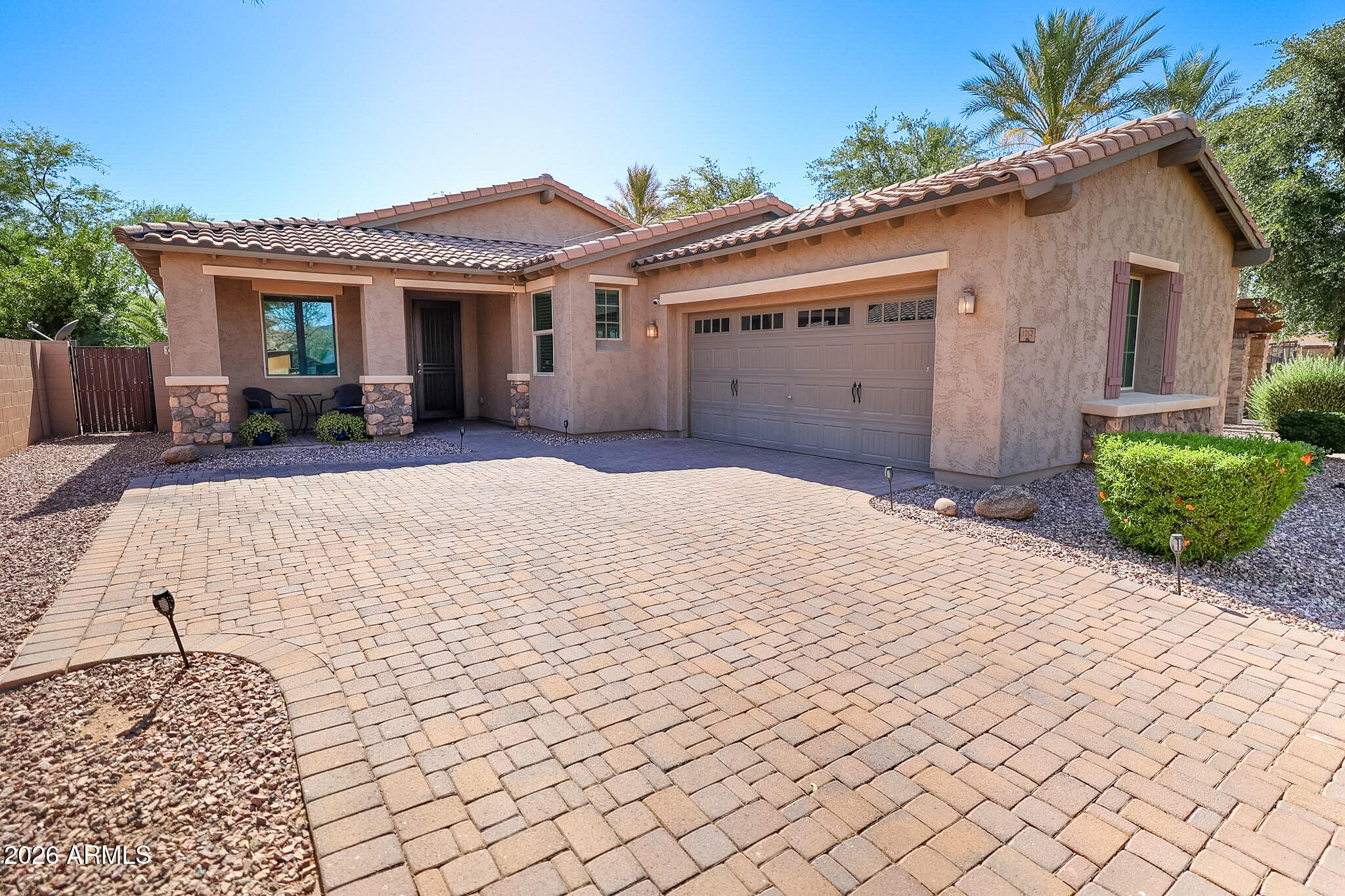 Welcome to Camelot at Palm Valley! This beautifully maintained 3 bedroom, 2 bathroom home has the kind of features buyers hope to find but rarely get all in one place. From the sparkling pool and owned solar to the corner lot, RV gate, and paver driveway, this home checks a lot of boxes before you even step inside. The split floor plan offers privacy and functionality, while the open kitchen features stainless steel appliances, granite counters, maple cabinets, a walk-in pantry, and an island perfect for gathering. The cozy den with fireplace adds a great extra living space, and the spacious primary suite includes dual sinks, a separate tub and shower, and a huge walk-in closet. Step outside to enjoy the screened-in patio, artificial turf, pool, and extended side yard built for relaxing and entertaining. Located in the gated Camelot at Palm Valley community with a heated pool, parks, sport courts, and more, this home offers the kind of Arizona living people move here for.