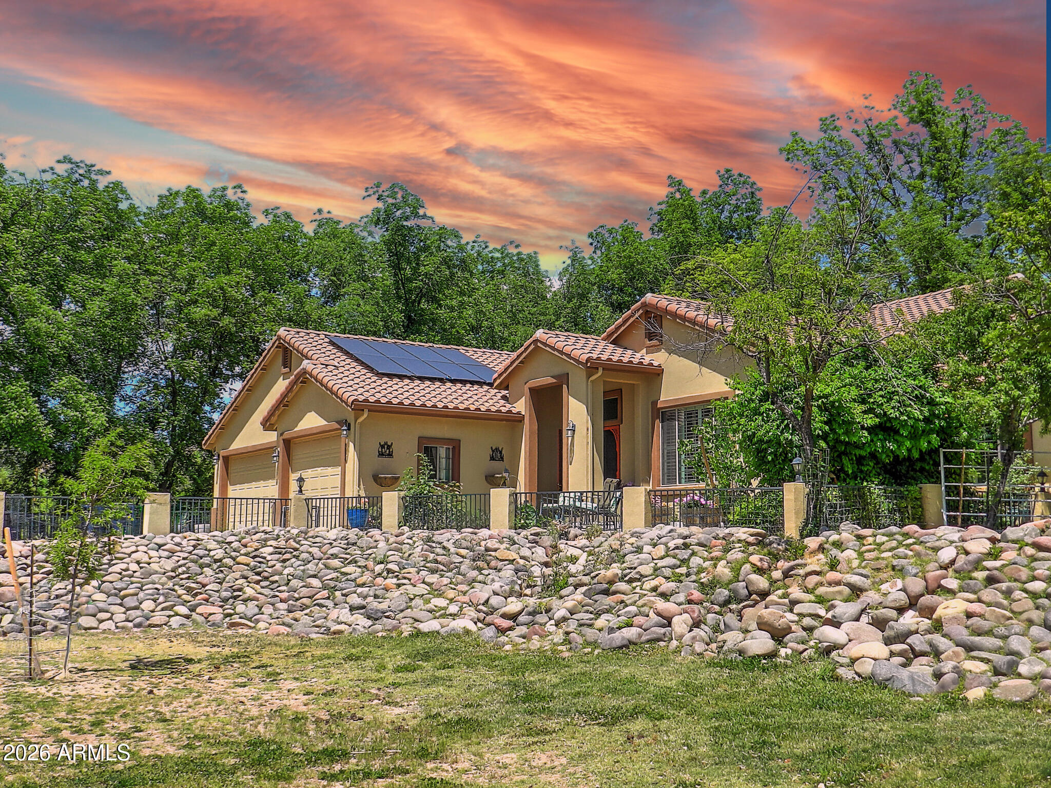 Timeless elegance meets serene country living in this custom Spanish-style home on 1.5 irrigated acres, With the front half a pasture & the back half the ranch, includes a rustic barn and a new tuff shed.  30 pecan trees that pay for themselves, plus mature fruit trees with flood irrigation provided by the historic Verde Ditch. Designed for both comfort & quality, the home features a split floor plan with a Jack & Jill bathroom for the two guest bedrooms, a gourmet kitchen, an oversized 3-car garage with an infrared sauna and a ¾ bath, a luxurious Japanese soaking tub in the master suite.  The elevated homesite overlooks the lush front pasture, creating a peaceful ranch setting with seasonal winter mountain views. This 3-bedroom, 3-bath retreat offers refined rural living with horse and farm animal privileges and no HOA. Take advantage of the low 2.625 interest assumable VA loan for qualified buyers. A list of all the upgrades and improvements is available. The sellers have done all the heavy lifting, now you can just enjoy the home.