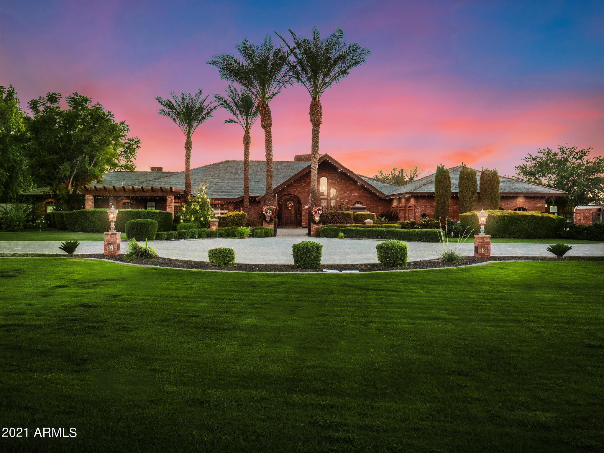 Located on 1.48 acres in the heart of Mesa citrus groves, this sprawling 9,966 square foot estate boasts six bedrooms, five full & two 1/2 baths, and exquisite design details including an imported slate roof, hardwood flooring, and brickwork finished by an artisan bricklayer. Highlights range from a completely remodeled kitchen, formal & informal living spaces and multiple brick fireplaces to an impressive primary bedroom with sitting area and fireplace.
This all-brick home has tons of features for your buyers. Guests will feel right at home in the walkout basement with its own kitchen, living area, game room, bedrooms, workout room and lots of storage. Car enthusiasts will marvel at the spectacular detached garage/workshop complete with a hydraulic lift as well as plenty of parking for.. cars, boats, or RVs. The spacious backyard offers complete privacy and creates an oasis-like resort feel with an expansive deck, built-in kitchen & grill station, all-tile pool, and spa with its own ramada. The spacious 20' wide pavered circular driveway welcomes you to a front gated courtyard with relaxing water feature and private sitting area, while a second 20' pavered driveway leads you to a privately gated motorcourt for additional parking space.