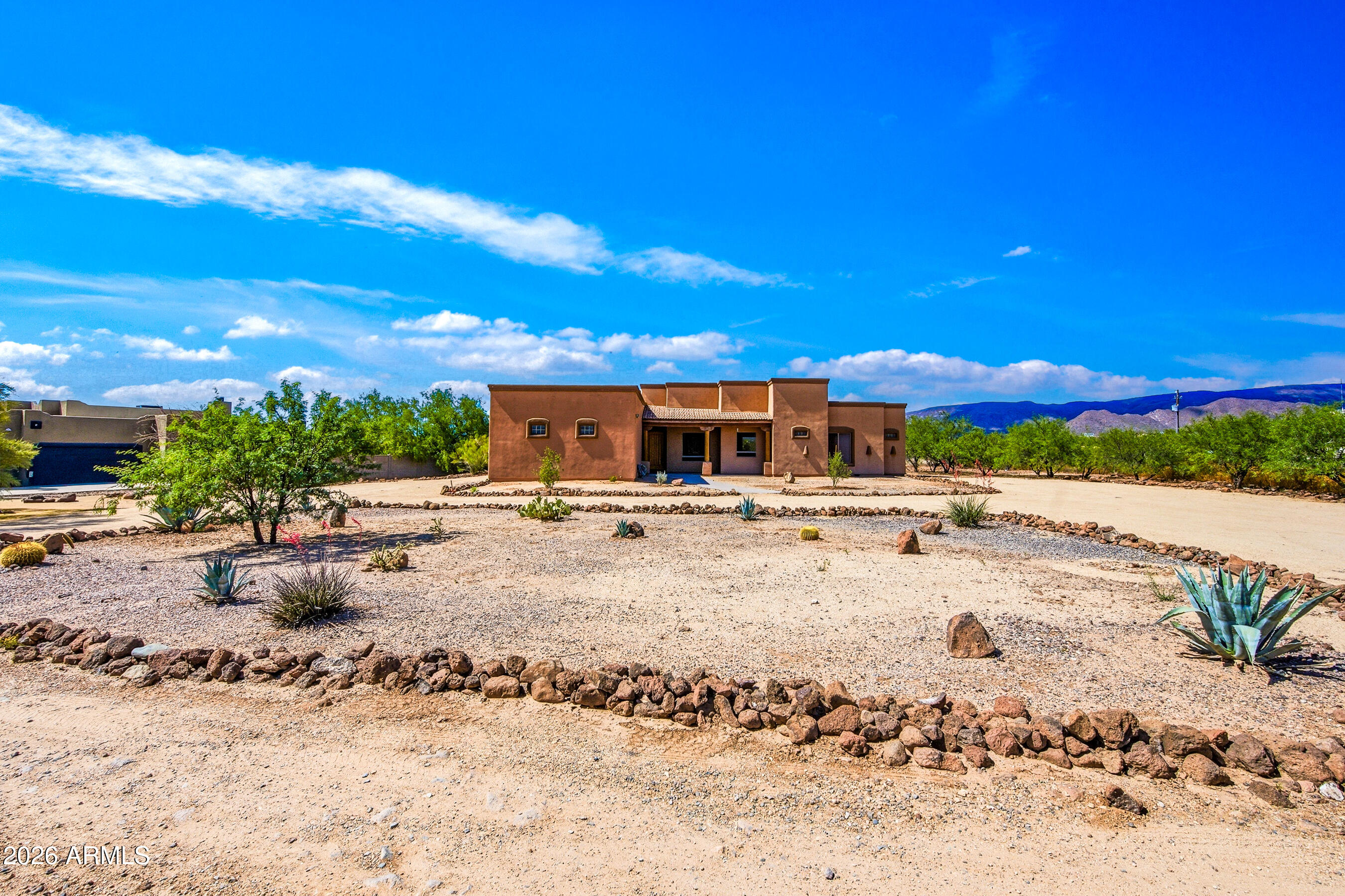 **NOTE** The house will be completely painted white by 6/20 some photos are virtually painted.  Ignore the green. ENJOY WIDE OPEN SPACES. Enjoy unforgettable sunsets, stunning mountain views, and the epitome of desert living on 1.25 acres just a stone's throw from Tonto National Forest. This beautifully appointed home offers a spacious split floor plan with 4 bedrooms, 3 baths, a formal dining room, and a dramatic great room with soaring 10-12 foot ceilings, Vega poles, a cozy fireplace, and seamless flow into the open kitchen. With three fireplaces; one in the great room, one in the primary suite, and one on the patio  the home offers warmth, character, and inviting spaces both inside and out.
Designed for both everyday living and entertaining, the kitchen features knotty alder cabinetry Kitchen has chiseled-edge granite countertops, stainless steel appliances, double ovens, a warming tray, a massive walk-in pantry abundant storage. Wood-look tile extends throughout the main living areas, complemented by 8-foot solid wood interior doors, rich architectural details, surround sound, central vacuum, and a water softener for added comfort and convenience.
The private primary retreat is a true escape with travertine finishes, a jetted tub, multiple shower heads, dual sinks, oil-rubbed bronze plumbing fixtures, its own fireplace, and a massive walk-in closet. Outdoors, enjoy expansive covered patios, extended pavers, a circular driveway, RV access with parking, and a cozy patio fireplace, all surrounded by wide-open desert beauty and breathtaking mountain views.
An extended 4-car garage provides plenty of room for vehicles, storage, and all your toys. Enjoy the freedom of true desert living near Tonto National Forest, with easy access to hiking, horseback riding trails, and the coveted Arizona outdoor lifestyle.