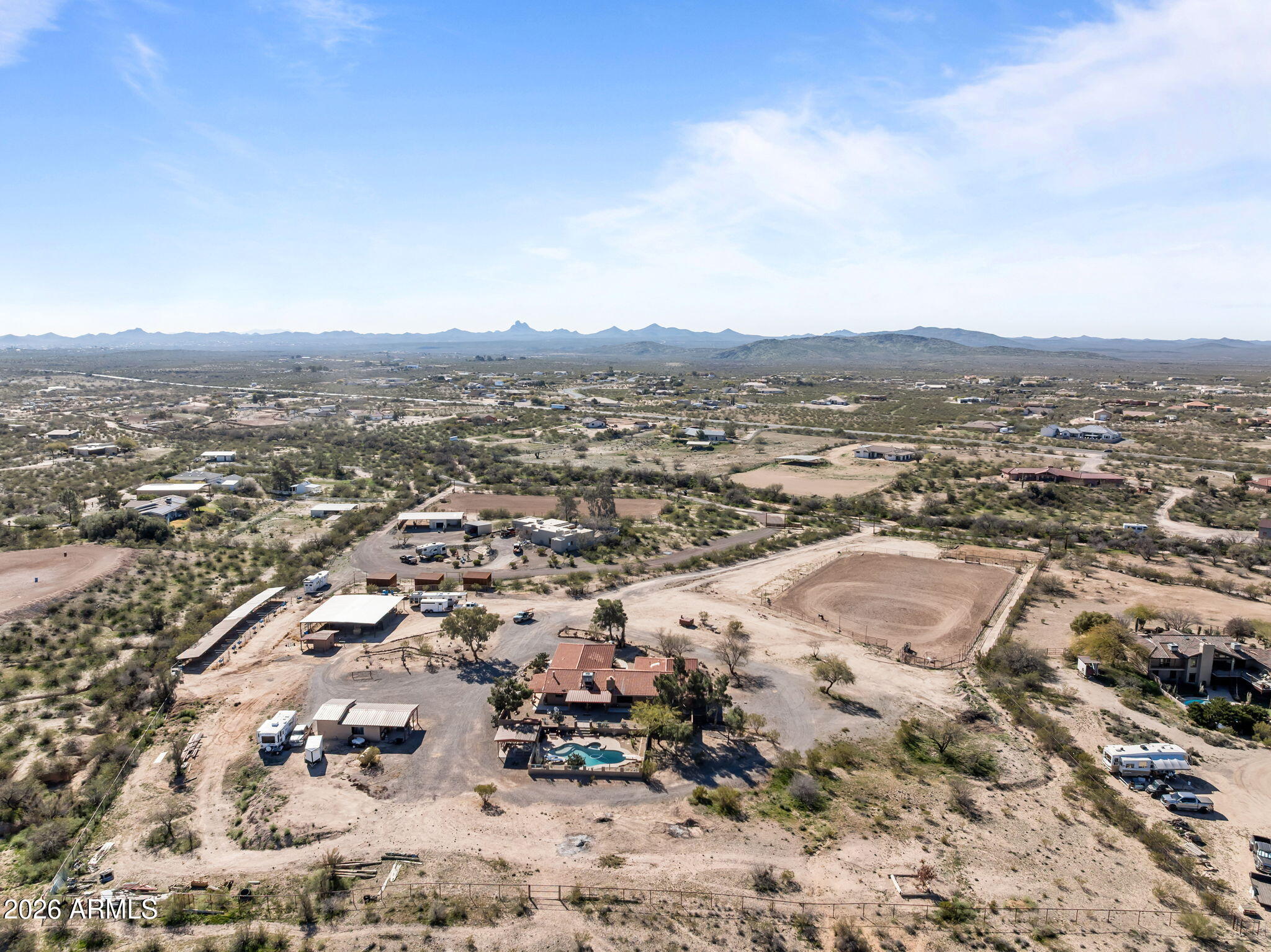 NEW PHOTOS COMING VERY SOON .Exceptional 6.8-acre horse property backing directly to State Land, offering privacy, functionality, and a true Western lifestyle. The fully fenced property features no-climb fencing, a gated entry, and extensive landscaping throughout. Designed for serious horse use, the ranch includes a piped full-size roping arena with sprinklers, a 4-stall mare motel with hay storage (with the ability to convert to an 8-stall setup), and four RV hookups, making it ideal for hauling, guests, or seasonal living. A private well services the property.The two-story home offers a versatile layout with up to six potential rooms, allowing flexibility for additional bedrooms, office space, gym, or guest accommodations. Recent upgrades include two new A/C units. Outdoor living is highlighted by a saltwater pool, perfect for enjoying Arizona evenings. Improvements include an attached garage and a detached garage suitable for a shop, storage, or potential guest quarters. With direct access to State Land and a well-designed equestrian setup, this property delivers space, usability, and lifestyle in one complete package.