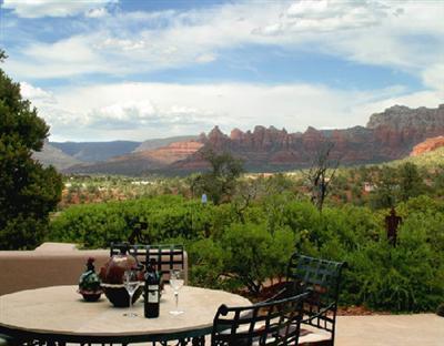 HILLTOP HACIENDA on 1.46 acres. Breathtaking mountaintop panorama commands center stage. Approximately 8900 sqft with luscious master suite, gourmet kitchen, large entertaining area, studio with bath and media room plus separate guest wing with two bedrooms, two baths and family area. Grand scale architecture impeccably detailed to emulate an authentic adobe featuring natural flagstone floors and rustic wood accents. Community pool and tennis. All furnishings, fine art, available separately. Sensational!