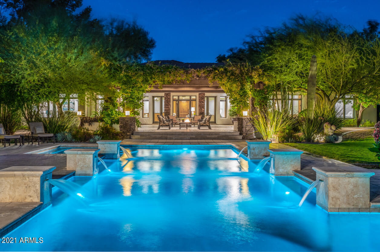 ONE OF A KIND PV estate boasting 1.25 acres of total privacy! ENTERTAINER'S DREAM! The 5 star resort like backyard features a heated lap pool with water falls, lush foliage, stunning 2,000+ sq ft RAMADA with a full kitchen, 2-way fireplace, gas heaters, bathroom, and outdoor shower! Green grass, towering trees, flowers, sport court, and mountain views. Indoor/outdoor living at its best!

Split floor plan with 2 separate family rooms, formal dining and living room, open concept kitchen, and a huge master bedroom with walk-in-closet and direct access to the backyard and pool area. Chef's kitchen features granite countertops, Dacor commercial 6 burner gas cooktop, Subzero appliances, and large island with breakfast bar. Open the front door and you are immediately greeted with the gorgeous view of the backyard. Walking past the charming sitting room featuring a gas fireplace, and the beautiful formal dining room, you enter the heart of the home: an open concept chef's kitchen and great room. The primary bedroom with a separate office is situated on one side of the home, while the other bedrooms (each with its own walk-in closet) are conveniently located on the other, with their own bonus room/family room area. The home is equipped with a Control4 automation system that controls the integrated audio system throughout the house, thermostats, pool equipment, and security system. When stepping onto the back patio overlooking the sparkling, heated lap pool with six water features, you will notice a built-in fire pit, BBQ, and commercial grade misting system to keep you comfortable during those hot AZ summer days. Walking past the pool, you will arrive at the massive ramada that is sure to impress with multiple seating areas, a dining area, a full bar and kitchen (including oven, microwave, BBQ, dishwasher, and full-sized refrigerator), a two-way fireplace, commercial-grade gas heaters, a bathroom and an outdoor shower. For some fun activities, enjoy the biking/walking path that surrounds the property, shoot some hoops on the basketball court conveniently located next to the ramada, or play some yard games on the large grass area. The backyard of this property is truly magnificent, you won't find another one like it!
