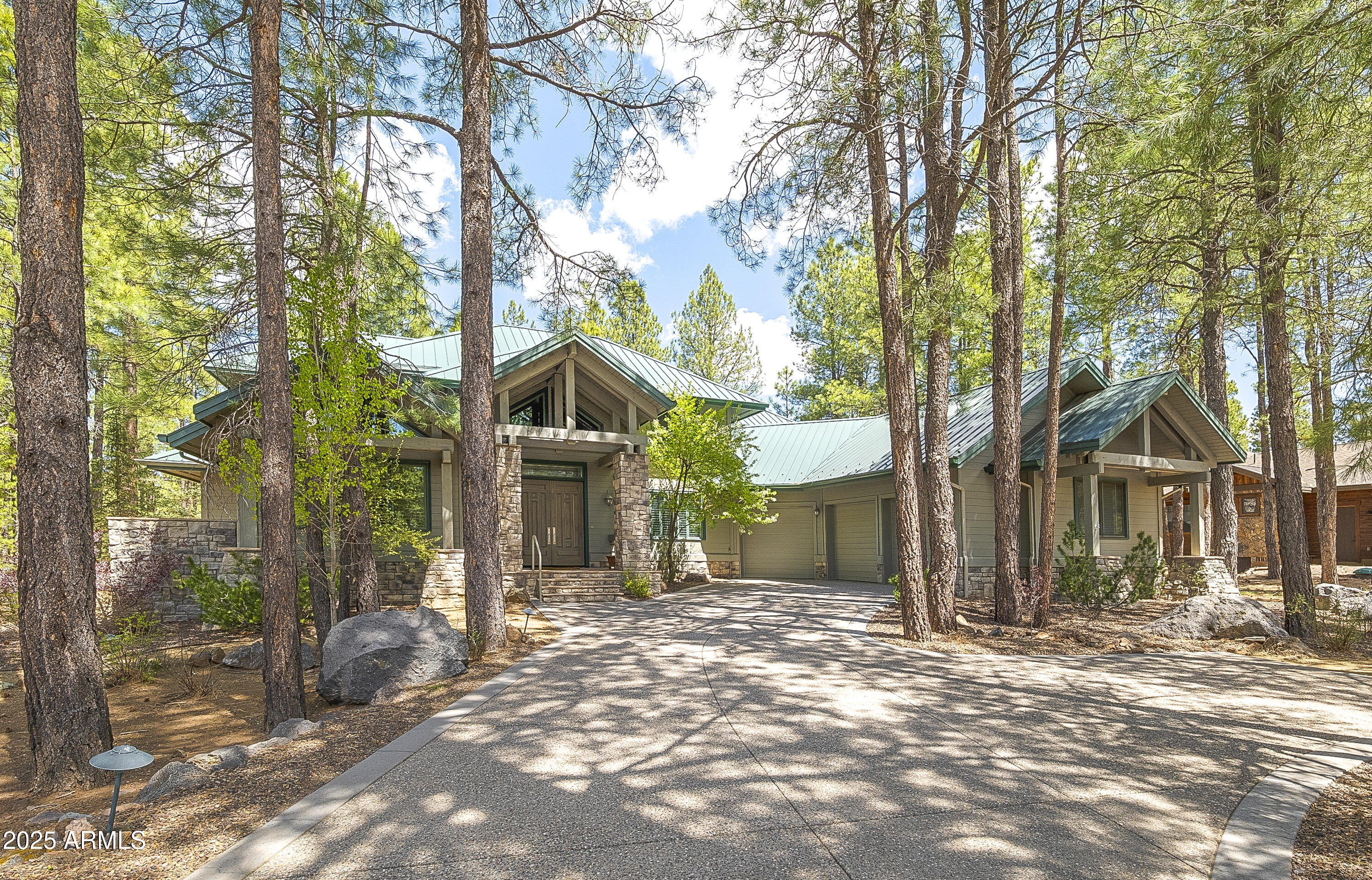 This elegant and welcoming Forest Highlands' home is turnkey-ready for a summer get away, or a full-time residence.  With beautiful curb appeal and situated on over half an acre at Hole #13 on the Meadow Golf Course, the home's tasteful landscaping surrounds incredible outdoor living areas encompassing both covered and open deck space, with ceiling fans, built-in grill and gas fireplace, as well as cozy patios to enjoy the fresh mountain air and vistas of the surrounding forest. Inside, the bright foyer leads to peaked open-beam ceilings and ample bright, natural light in the living area.  The gas fireplace in the living room helps to take the chill off mountain mornings, where you can enjoy views of the trees as the day comes to life.  The kitchen is a cook's playground, with amazing storage, island with a separate sink and eat-at granite counters, built-in gas range and dual ovens.  With the primary bedroom on the main level, designed with its own fireplace in a generous additional space for a library, exercise space or simply a quiet retreat, all living on the main level is easily had.  There are three additional bedrooms upstairs, each en suite, allowing for a comfortable stay for family or guests. This property is a perfect retreat to enjoy all that Forest Highlands has to offer.