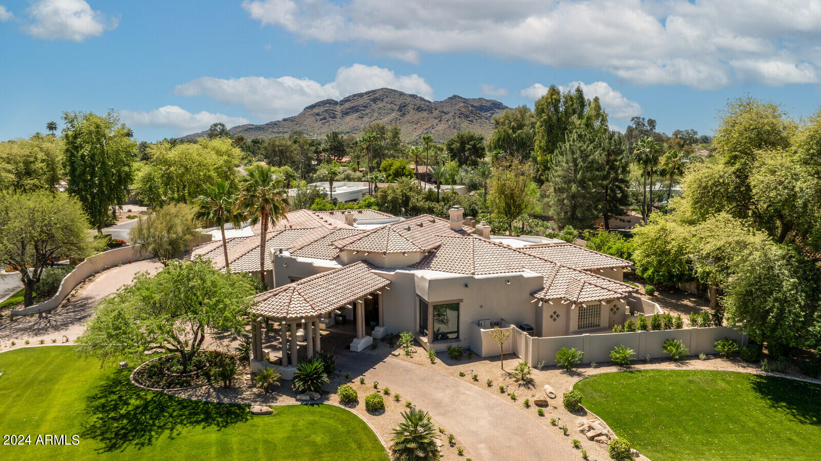 This luxurious estate is located in the gated Hidden Paradise neighborhood of Paradise Valley, an exclusive enclave known for its seclusion and prestige, featuring 17 exceptional homes which are rarely on the market. As you approach the property, the beautifully landscaped grounds catch your eye, leading you to the circle driveway with a porte-cochère. The grand entrance of the home features a striking 10-foot door that opens into a beautiful stone foyer, offering a glimpse straight through the living room and out to the outdoor spaces. The recently renovated home boasts stunning grounds, light and bright lavish interiors with spacious rooms, soaring ceilings and expansive high windows that bring the outdoors inside. New hardwood floors add warmth and elegance to every room, complemented by beautiful 8-ft wood doors throughout. The property provides an abundance of entertainment spaces, starting with a spacious living room featuring a grand fireplace, an elegant dining room, a butler's pantry and chef's dream kitchen equipped with top-of-the-line Subzero, Wolf, and Miele appliances, double ovens and dishwashers. This culinary haven seamlessly opens up to a vast family room, creating an ideal space for gatherings. Additionally, there is an enormous game room with a wet bar for entertaining and a versatile bonus room, that can easily be converted into an attached guest house. The expansive primary suite is a luxurious retreat within the home, offering a comfortable sitting area, a lavish bathroom complete with oversized steam shower and spa for relaxation, and a meticulously designed and spacious custom closet with over 30 drawers and 18 glass doors to accommodate all your wardrobe needs. Four bedrooms have ensuite bathrooms, while the fifth bedroom is currently used as an office. The backyard oasis includes a refreshing pool and spa, an outdoor fireplace for cozy evenings, a putting green with sand trap, expansive grassy area for sports and activities, and a charming secret garden. The property includes a four-plus car garage and is situated in the sought-after 'three C's' school district, making it an ideal location for families looking for top-rated schools and a luxurious lifestyle.