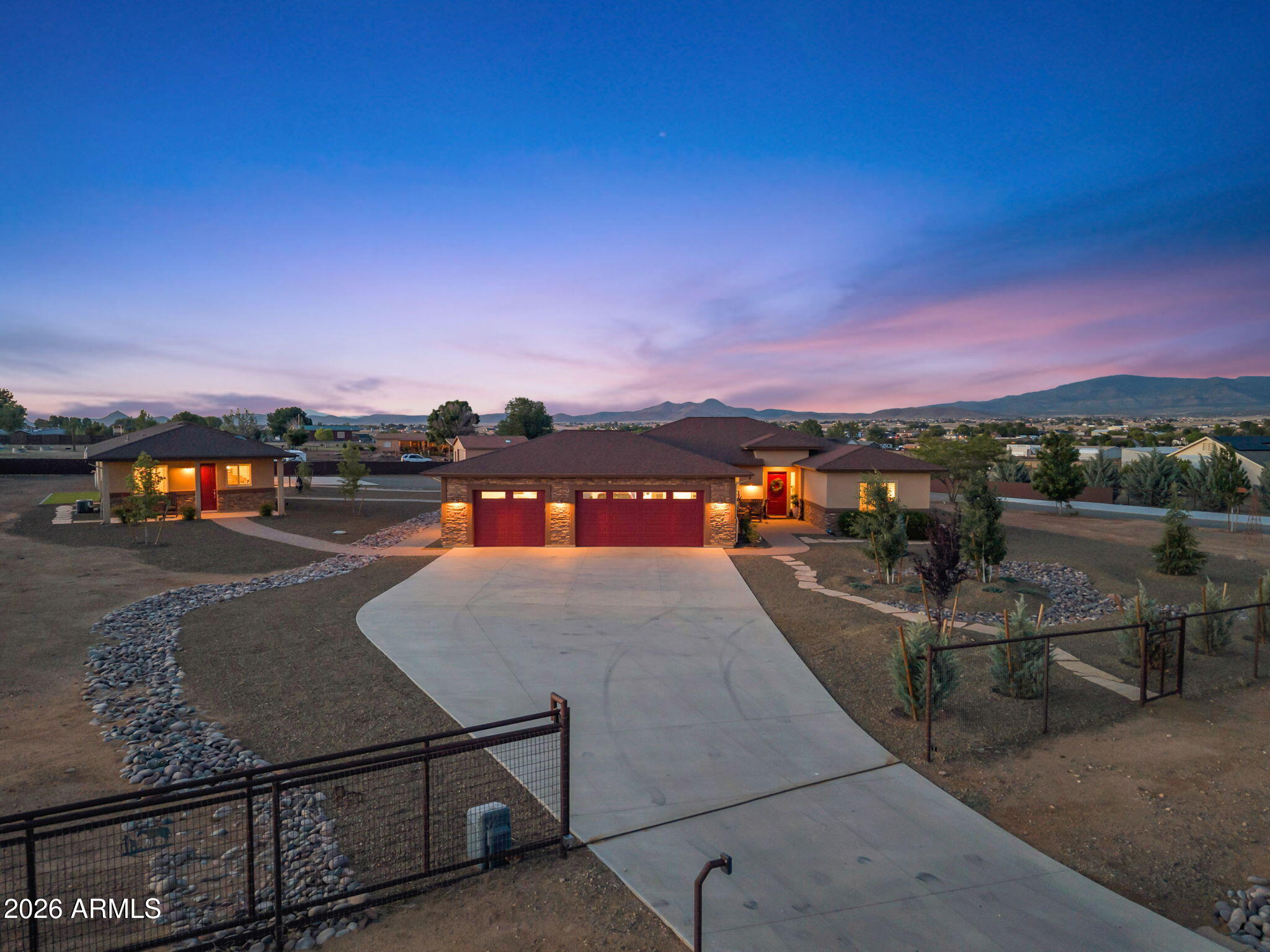 One of a kind country estate on 2 acres in the Poquito Valley neighborhood of Prescott Valley. Built in 2015, the main home features 3 bedrooms, 2 bathrooms and an office/den with modern design and amenities befitting a luxury home. The gourmet kitchen includes a spacious island, stainless steel appliances, and a separate pantry. A great room includes a gas fireplace with gorgeous stone surround. The primary suite includes an en-suite bathroom with dual sinks and a beautifully-tiled shower, a walk-in closet with custom-built cabinets, and convenient access to the separate laundry room. The attached 3 car garage, with recently added epoxy flooring, plus a Tesla charger, rounds out this upscale main home floor plan. This property also includes a detached 767 sqft, 2 bedroom, 1 bathroom guest house, with modern design, a full kitchen, and roomy living area. Perfect for guests, extended family or as a potential investment/rental! Another amazing feature of this property is the detached, electricity-enabled, 2,018 sqft garage, which is perfect for your various cars/trucks/toys. This 40ft x 50ft garage, with new epoxy/stained flooring, also includes a separate workout/storage room and reinforced storage cabinets. The property is fully fenced with two large rolling access gates. This spacious estate also includes a wood-burning backyard fireplace, a storage shed with standard and roll-up entry access, recently installed backyard privacy metal fencing, and tasteful landscaping throughout. This property is luxury Prescott Valley living at its finest - come see it today before it's gone!