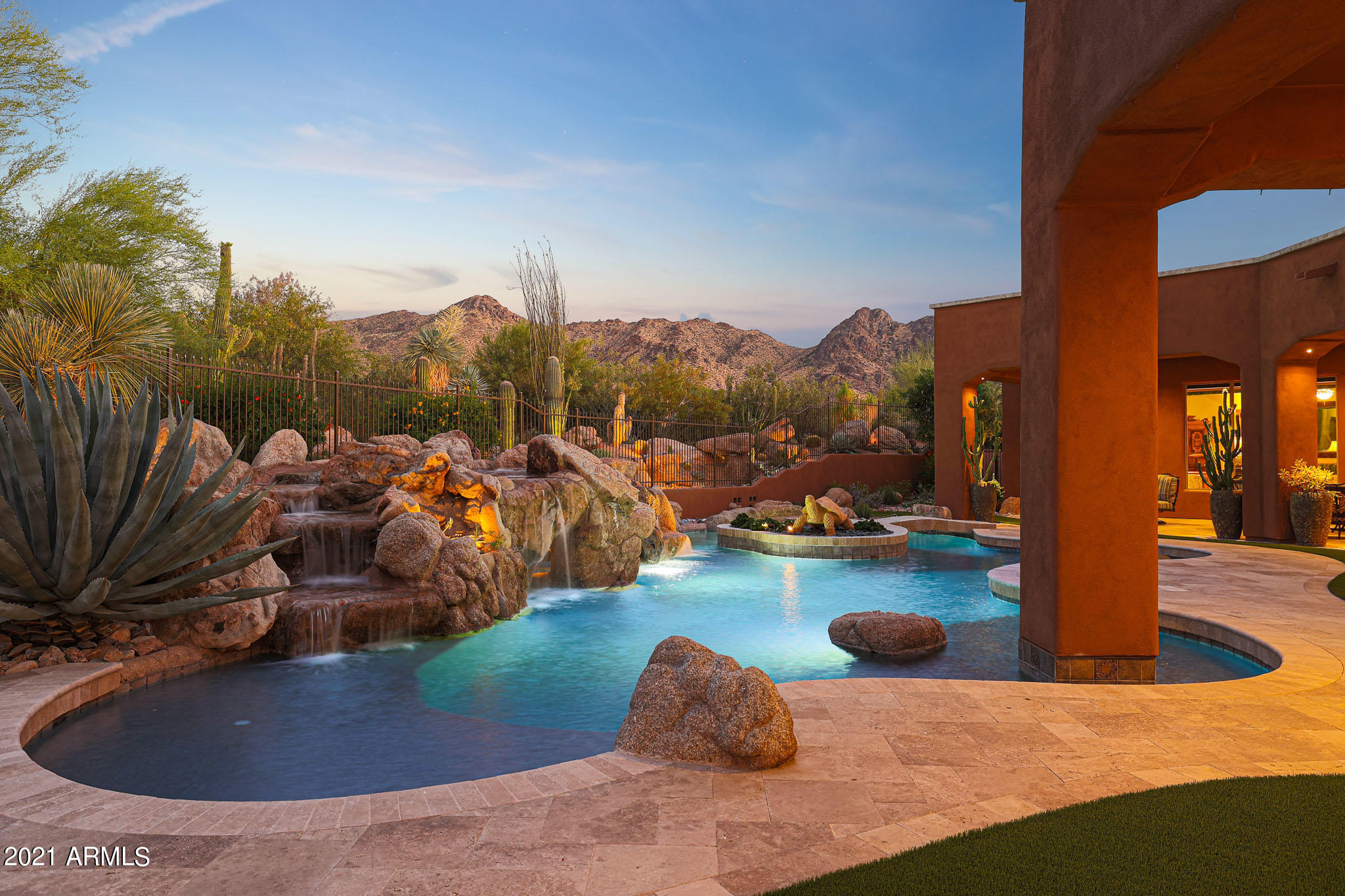 Gated Sonoran Crest in North Scottsdale and the McDowell Mountain range lay the backdrop for this stunning extensively upgraded estate.  Featuring five bedrooms (one is set up as an office with built-ins), five and a half baths and a five car garage. In addition to the ensuite bedrooms there is also a den and a media room/bonus space. Upgraded features include: Control 4 all home automation system, interior and exterior LED lighting, hardwired sunscreens, 4 Trane high efficiency HVAC systems, new elastomeric roof and so much more. This former model, single level home features smooth white walls, beautiful wood details on the ceiling and trim, natural stone floors and surfaces, and a separate entry casita with a full kitchen, great room and private bedroom and bath. At over an acre, this lot has an eastern exposure backyard that is an entertainer's dream with a large pool with rock grotto waterfall, spa with entry bridge, built-in table and seating, baja shelf, beautifully redesigned landscape and lighting, artificial turf, new travertine hardscape, built-in barbecue, and a large covered patio extending the length of the yard. 
Providing a true chef's experience, the kitchen is outfitted with four ovens, granite counters, gas cooktop with griddle, custom wood cabinets with matching hood vent, large center island and countertop seating. The kitchen is flanked by the full wet bar with additional seating, all open to the family room with centerpiece fireplace and built-in entertainment center, basket weave wood ceilings, stacked stone accents and numerous view windows overlooking the backyard and mountain views. The owner's retreat has a fireplace, exterior access, sitting area, wood floors, and a large bathroom with dual vanities, large soaking tub, walk-in shower, and his and hers closet space. (