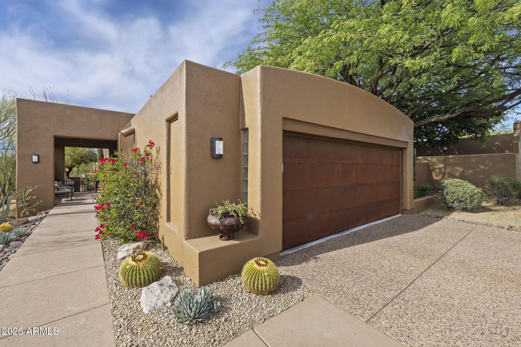 Nestled in the desirable Skyranch at Carefree gated community, this beautifully designed home greets you with 15' high beamed ceilings, clerestory windows and a stunning desert/mountain vista. The old-growth bamboo floors and gas fireplace add ambience to the living and dining areas. The kitchen includes a new Subzero refrigerator and a granite island area perfect for coffee or cocktails, with nearby display  shelves and bar storage.
The oversized primary suite is a master retreat with its own fireplace and sitting area. The guest room offers access to a private courtyard with a fountain, that is also a perfectly enclosed play space for pets. The extended outside patio features a landscape of specimen desert plants, dramatically lighted at night. A relaxing spa and built-in banquette - afford the ideal spot to entertain, unwind or watch the sunset. Additional highlights include a private sauna in the garage along with 220V service for an electric vehicle. This exceptional home combines comfort, style and tranquility surroundings in a remarkable package. Community amenities include a heated pool and spa, tennis court, dog  park and new asphalt roads.