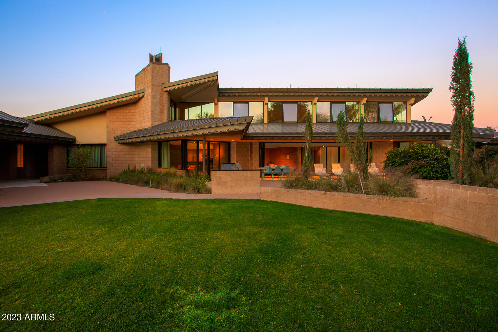 Frank Lloyd Wright influenced Desert Modern Design in AZ and none more than this serene and gated 2.5 acre compound in Paradise Valley. Taliesin trained Architect Gustad Irani incorporates Wright's concepts of organic architecture. Shading, breezeways and ceiling height direct light, air and for the most personal interaction. Unique geometry & timeless material palette bring metal, block and the southwest to life in this serene design. An ample home w/6 private bedroom suites, multiple kitchens, & garage for 6. Pools/fountains allow water to ebb into daily life. Mature landscaping pulls you out to explore blurring the lines for an in-and-out life. Tennis/Pickle-Ball/Sport Court/Putting green add to the fun. Best of all is the feeling of living in 'inhabited art' in this elegant estate! WOW