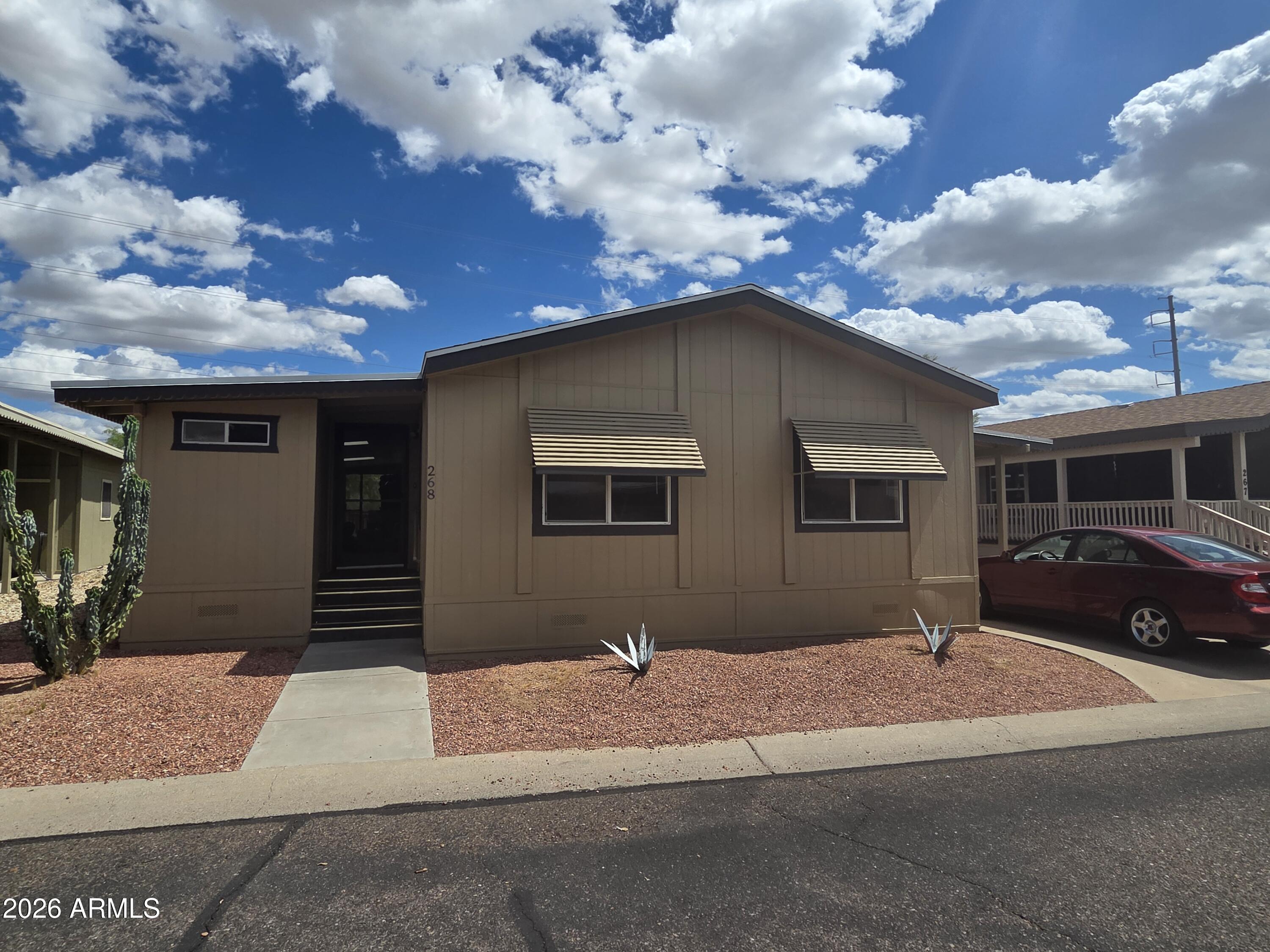 Paradise Peak West is a vibrant 55+ community located at the heart of the Arizona lifestyle. BACK YARD CAN BE ENCLOSED W PPW APPROVAL. This property is sold As-Is, will need flooring including base flooring and interior updates.  
FEATURES: Raised-panel cabinets, recent exterior paint, a New HVAC system (approximately two years old), and a $9,000 side patio conversion to a spacious Arizona room. The Arizona room features skylights, windows, and an integrated second storage area, fully equipped with electric, and a separate rear patio area designed for a BBQ and television setup.  This unit backs up to a wash/common area. Closest comparables are 140k plus without the Arizona Room Addition and Newer HVAC and Roof Shingles.