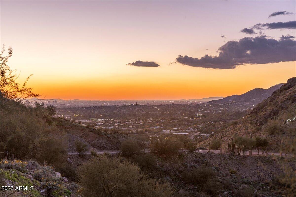 Perched at the very top of Mummy Mountain, this extraordinary 5.17-acre
homesite represents one of the last truly irreplaceable parcels in Paradise Valley.
Located at the private end of Invergordon Road, this east-facing property offers
unmatched privacy, breathtaking day-to-night views, and the rare opportunity to
create a world-class luxury estate in one of Arizona's most prestigious settings. The property features a flat and expandable building area ideal for a grand custom
residence, thoughtfully positioned to capture sweeping panoramic views of the
McDowell and Superstition Mountains, glowing city lights, and unforgettable
sunrises. Afternoon and evening shade provided by the mountain creates a
naturally balanced and comfortable setting year-round. With paved road access, no HOA restrictions, and electric, water, and natural gas
conveniently located at the property line, this homesite offers exceptionalflexibility and ease of development. Just minutes from Paradise Valley's finest luxury retail, five-star dining, and resorts, this location delivers seclusion without sacrifice. This is more than landit is a legacy opportunity. If you can dream it, you can build it.