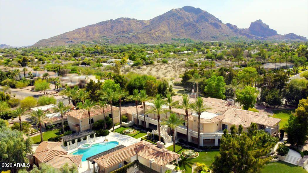 One-of-a kind Private walled and gated Estate in the center of Paradise Valley not far from the new Ritz Carlton. LOVE the home or CREATE YOUR DREAM ESTATE on this SPECTACULAR 3.25 acre lot. Interior and exterior painting done early 2022. Renovated in 2012 (by previous owners) with well made custom cabinetry, marble flooring, and high end appliances/fixtures. Estate includes a newer 2bed/2bath Guest House, FULL-SIZE INDOOR BASKETBALL Court, Lighted Tennis Court, Swimming Pool+Spa, Vegetable garden, Citrus grove, Home Theater, Wine Cellar, garage parking for 8 + MORE. Mountain Views and Immaculate mature landscaping with custom fountains + a private well to water the grounds! Very rare with 2 gated entries to the estate. Possibility to split lot. Don't miss this unique opportunity.