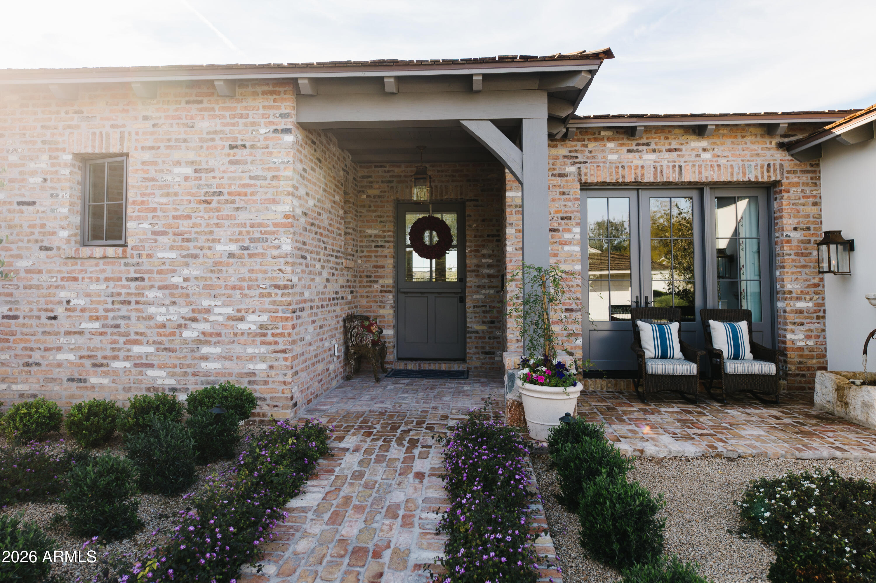 Welcome to a one-of-a-kind jewel box nestled in the gated community of Mountain Shadows East. Featuring Reclaimed beams from Quebec, Gas lanterns from New Orleans ,Chicago brick and custom cabinetry by Burdette . The layout is thoughtfully designed with  a master suite, guest suite, third bedroom used as a dual office and a music room. Butlers pantry and coffee bar off open concept kitchen , a separate eating area with niche fireplace and stunning Camelback mountain views are just two examples of living well. Outside the charm continues with a welcoming front porch ,Dutch door and  fountain . The  deep covered back patio looking onto the pool and fire pit and open area is lush.  A custom built masterpiece ,this home is a testament to craftsmanship, history and the art of fine living