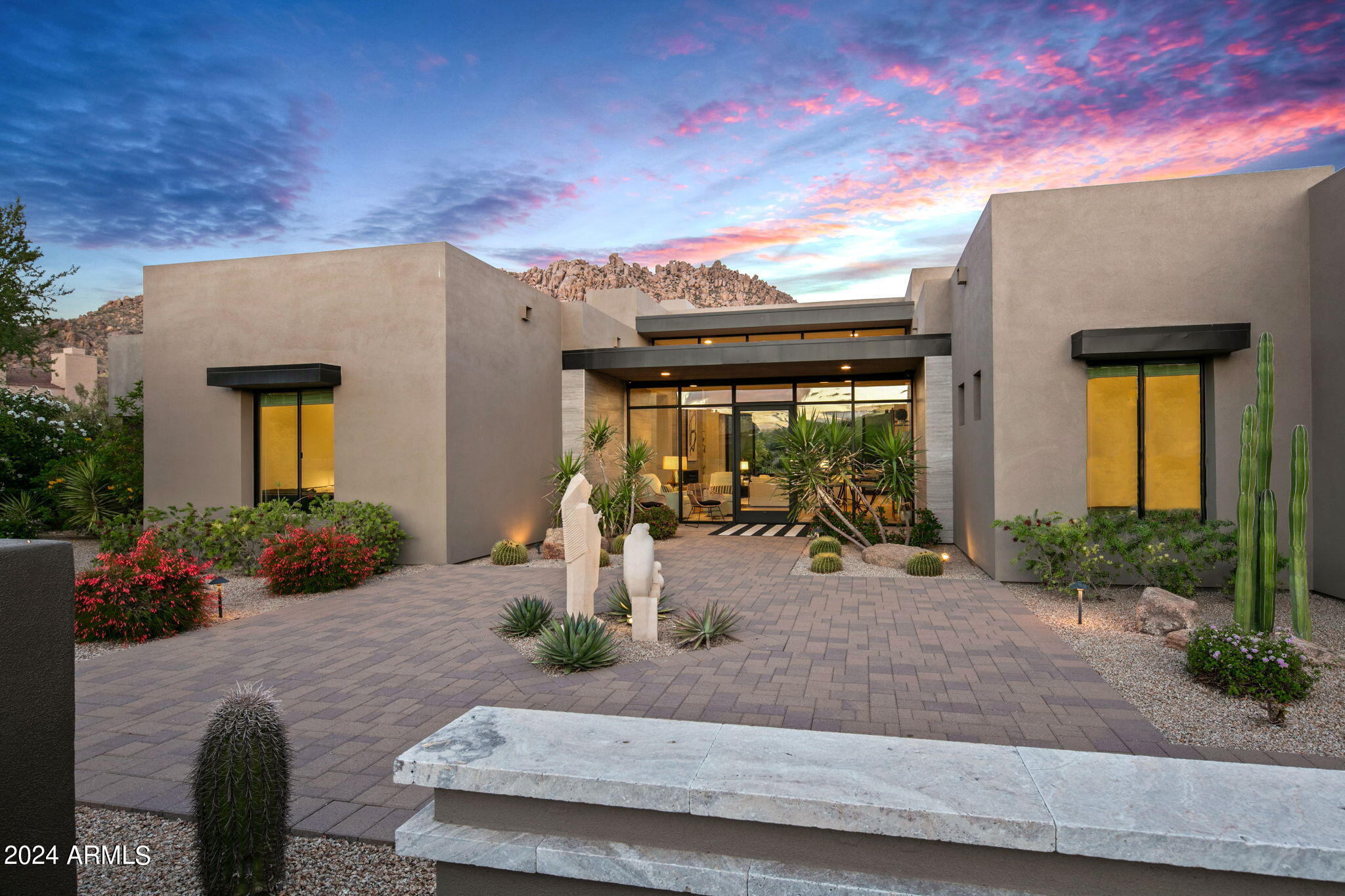 Step into the epitome of desert luxury living. Residing within the exclusive guard-gated community of Windy Walk Estates at Troon Village, this home offers an oasis of tranquility and prestige. Built in 2018, this modern and elegant residence was situated to showcase mountain views from every room. Upon entering, you are greeted by floor-to-ceiling windows and doors that accentuate the natural light illuminating the family room and kitchen.Designed to embrace its breathtaking surroundings, the residence features steel-framed entry glass doors and custom windows, flooding the great room with natural light. Unwind beside the custom gas fireplace, boasting a captivating floor-to-ceiling tile surround and elegant stone mantle, seamlessly blending with the wide plank French oak floors. The heart of the home, the kitchen, is an entertainer's dream with easy access to both interior and exterior dining spaces. Enjoy top-of-the-line appliances, including a Subzero side-by-side fridge and freezer, Wolf appliances, a 48" gas range, steam wall oven, and convection wall oven. A 24" French door wine fridge and large center island complete the space, ensuring every meal is prepared with style and functionality. The dining room offers direct access to the outdoor living area, where you will find a wonderful covered patio with Troon Mountain as your backdrop. This space is perfect for entertaining, with mister fans, electronic sunshades, a heated pool, fire pots, and a gas BBQ. Entertain in style in the well-designed backyard oasis, featuring a pebble finish pool and spa, gas fire pit columns, built-in barbecue, and misting breeze fans.
The home boasts three bedrooms, including a primary suite with direct access to the outdoors. The primary bathroom has recently undergone an impeccable, fully elaborate remodel featuring heated marble flooring, a 6-foot custom glass wall voice-activated steam shower, a freestanding soaking tub with mountain views, and impeccable finishes. Accommodating guests is effortless with two additional en-suite guest rooms, each offering modern bathroom amenities and refined comfort. A versatile sitting room presents the opportunity for easy conversion into a fourth bedroom or an additional family room.Additionally, there is a fully air-conditioned private office off the garage with views of Pinnacle Peak. This space can be transformed into a private flex room or gym. Recent upgrades such as all-new custom interior and exterior painting, updated lighting, and a patio motorized sunshade add to the home's convenience and comfort. The three-car garage, featuring epoxy flooring and built-in cabinets, also offers an additional air-conditioned space with a view of Pinnacle Peak, ideally suited for a home office or gym. Experience the pinnacle of desert living in this remarkable home, where luxury meets serenity in perfect harmony. This exceptional property is designed for those who appreciate modern elegance and functionality, all set against the stunning backdrop of Arizona's natural beauty. Welcome to your modern oasis.