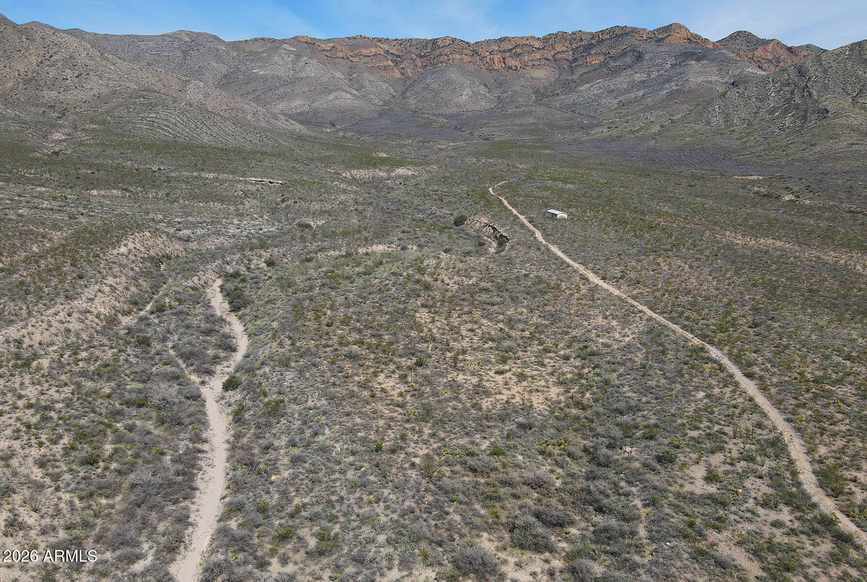 Rare and truly unique, this 285 acres offers complete seclusion in the rugged beauty of the Mule Mountains. Surrounded by BLM & AZ State Trust land, unmatched privacy, protection, and freedom are ensured. Tucked against the mountain, the property features a site-built cabin shell [requires renovation], and access road that winds through both parcels. Pretty high desert terrain with multiple dry creeks, canyons & hills to explore. Zoned RU-4 in Cochise County. Partially fenced with access gate to BLM land. Elevated hilltops capture sweeping views of the San Pedro River Valley and the Huachuca Mountains. Fascinating topography & geology. Total privacy, no through traffic, and direct access to vast surrounding lands. Strong candidate for private ranch, recreational retreat, or long-term hold. Seller holds equitable interest. Close of escrow contingent upon seller acquiring title.