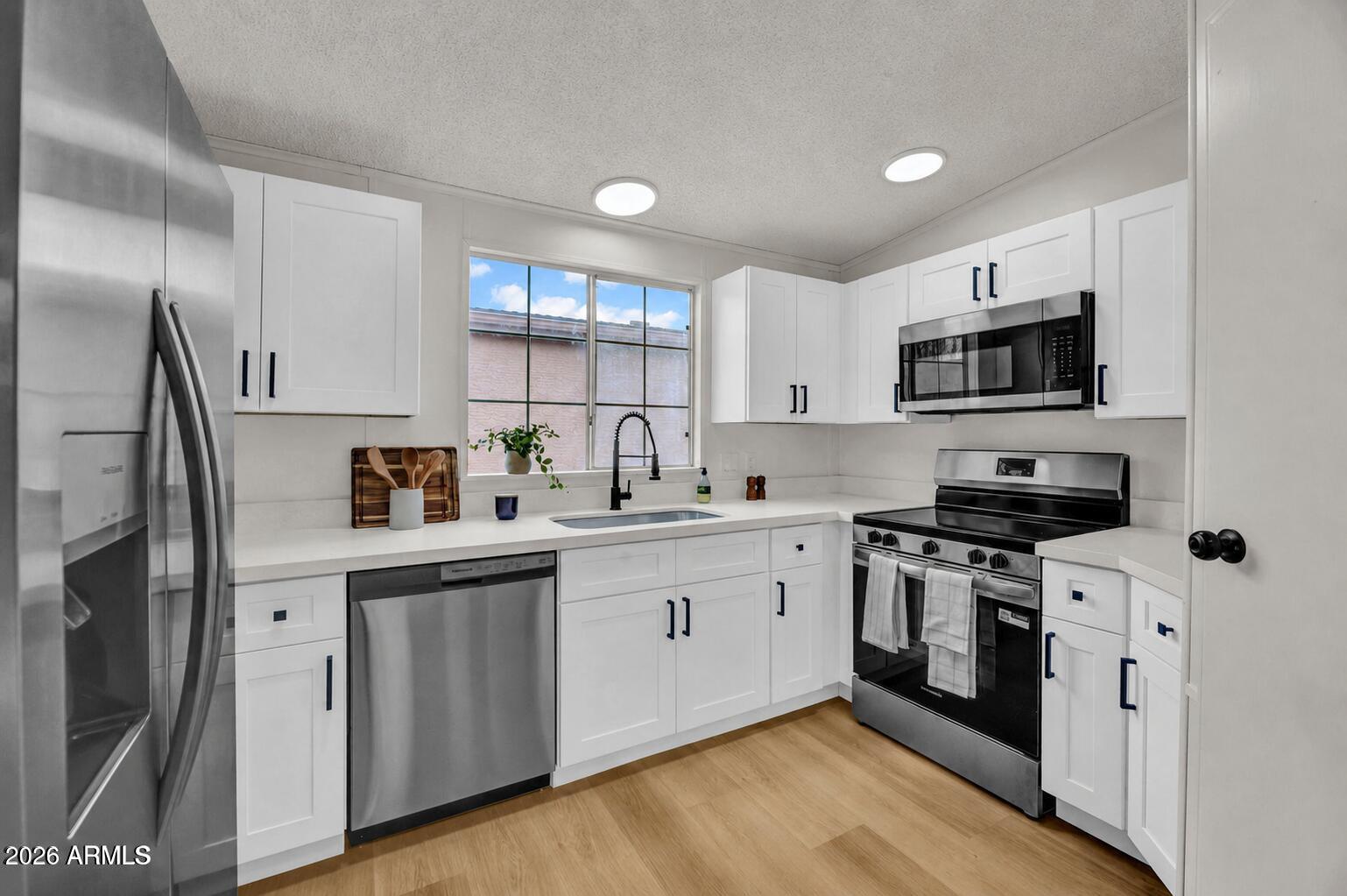 OWNED LAND! NO LOT FEE! Sunbird Gem! Enjoy peaceful, low maintenance living in your completely remodeled home! All new cabinets, counters, appliances, washer/dryer, paint, flooring and more! This is really a ''see if to believe it''. Quiet community with no landscaping! Come see this today!