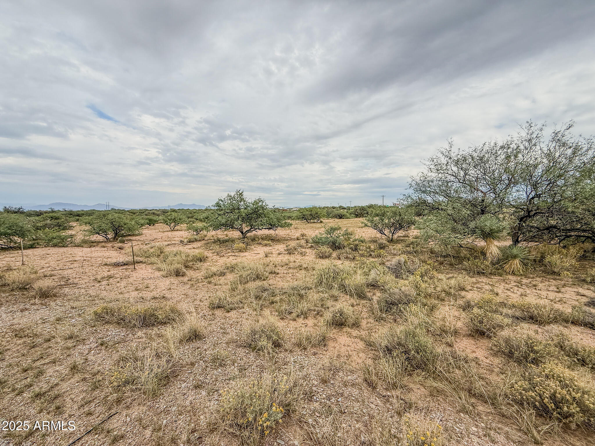 Discover 5+ acres of wide-open space just west of Benson, offering the perfect blend of rural tranquility and convenience. This level, usable parcel provides plenty of room for your dream home, horses, or hobby ranch—with beautiful 360-degree mountain views and stunning Arizona sunsets. Located just off Tequila Trail, the property offers easy access to I-10 for a quick drive to Benson or Tucson. Power is nearby, and there is abundant space for a private well and septic system. Experience peaceful country living with the freedom to create your ideal desert retreat!
The property is a 5.7-acre portion of 12406005B—survey to be recorded at closing.