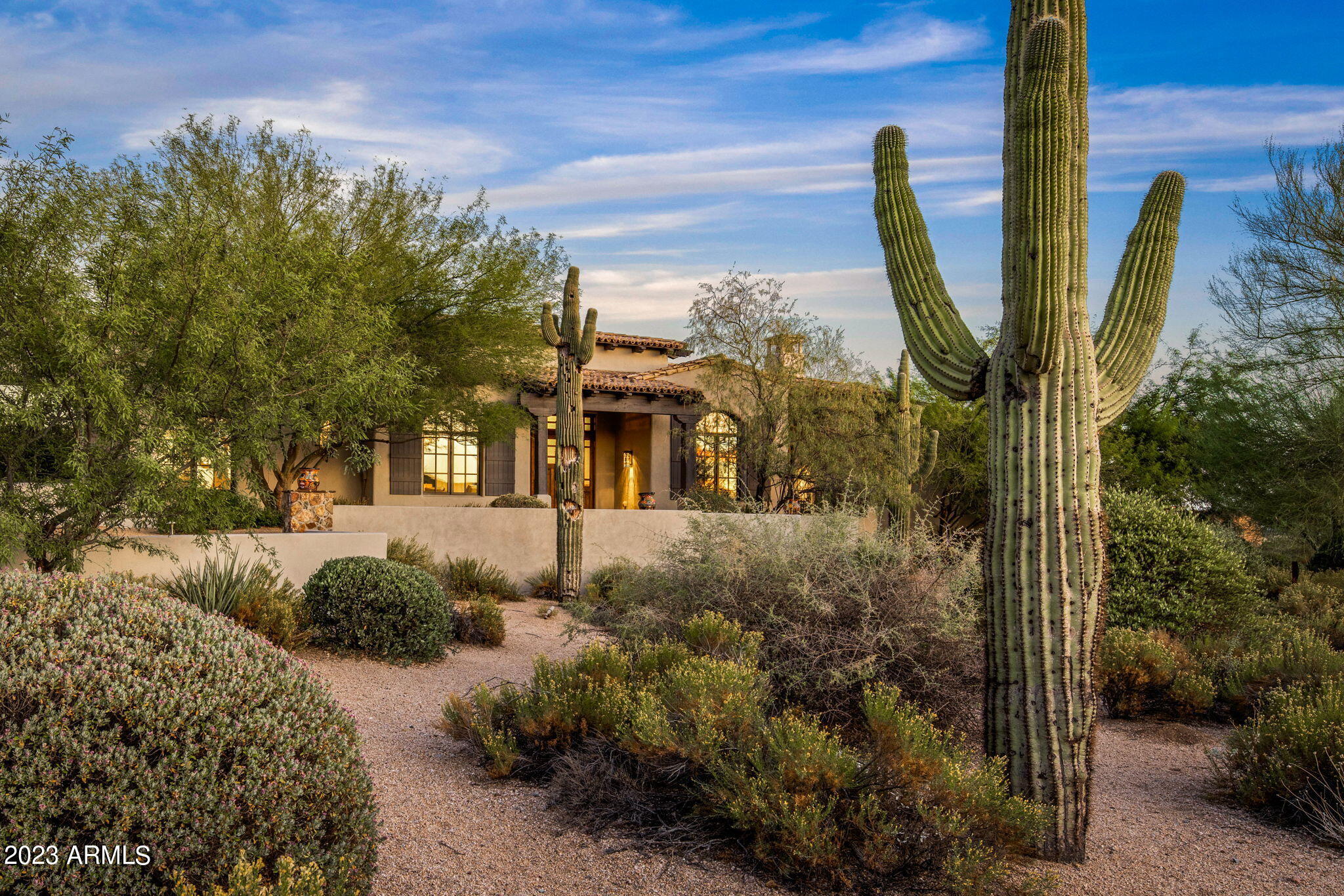 Very attractive ranch style home located on an elevated corner lot in the guard gated Mirabel Club community. This desirable floorplan boasts 4000 sq. ft. with 4 Bedrooms, office, 4 1/2 bathrooms & an oversized 3 car garage large enough for 3 cars plus a golf cart. One of the guest suites is a full mini-primary with a soaking tub & separate shower, dual sinks and walk-in closet. The home has many interesting ceiling details including massive beams in several rooms and an intricate brick groin vault in the entry foyer. Updates include new custom cabinetry and updated light fixtures. A large pocket door opens the great room up to the spacious backyard with an infinity edge pool, spillover spa, outdoor kitchen and putting green. Views of Pinnacle Peak and McDowell Mountains from the backyard