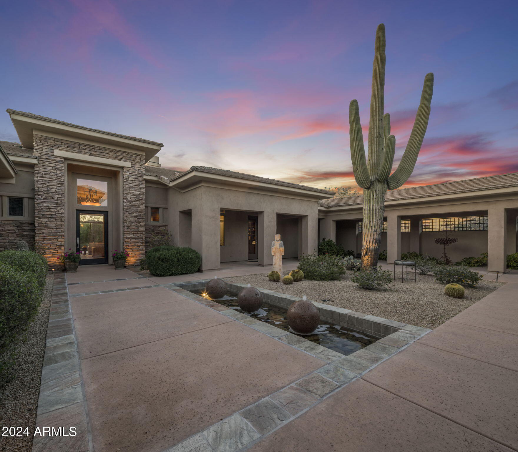 Presenting an unparalleled opportunity to own a masterpiece of luxury living, meticulously crafted by the renowned Toll Brothers in 2006. Nestled on a sprawling 1.22-acres, this exquisite Tereno model home is a testament to architectural elegance and sophisticated lifestyle. With an expansive 6,651 square feet of living space, this property is designed to cater to the most discerning tastes, offering 5 bedrooms, 5.5 bathrooms, and an array of opulent amenities. At the heart of this magnificent residence are two front courtyards that are ideal for entertaining or for enjoying the serene Arizona nights by the gas fireplace. The split floor plan ensures privacy and comfort. Each bedroom is ensuite, with the exception of one, providing the ultimate retreat click ''More'' for residents and guests alike. The primary suite elevates luxury to new heights with a sitting area with doors out to a private covered patio, gas fireplace, and the primary bathroom has dual water closets, a jetted tub, shower, and two generously sized closets. Beyond the bedrooms, this home is an entertainer's dream, featuring a chef's kitchen complete with a SubZero refrigerator, gas 6 burner range, additional wall oven, two dishwashers, and a large walk-in pantry for unparalleled culinary experiences. The family room, great room, dining room and stunning 360 bottle wine room offer diverse settings for relaxation and social gatherings. Enjoy the gas fireplaces in both the family room and great room. This property is all about indoor/outdoor living with sliders and French doors opening to a private resort-style backyard that backs to a lush desert wash with a putting green, outdoor barbecue kitchen, cozy fireplace, and spectacular pool and spa. The detached casita, with its full bedroom, mini kitchen, family room, and full bath, offers additional luxury and privacy. The property's four-car garage, split with a two-car detached configuration, adds convenience and ample storage. Located in a gated community, this home has a prime location that combines privacy with accessibility. The meticulous attention to detail, high-end finishes, and expansive, well-appointed spaces make this property a rare find. Whether you're hosting lavish parties or seeking a peaceful retreat, this home caters to both. Seize the opportunity to own a slice of paradise, where you will experience both luxury and comfort.