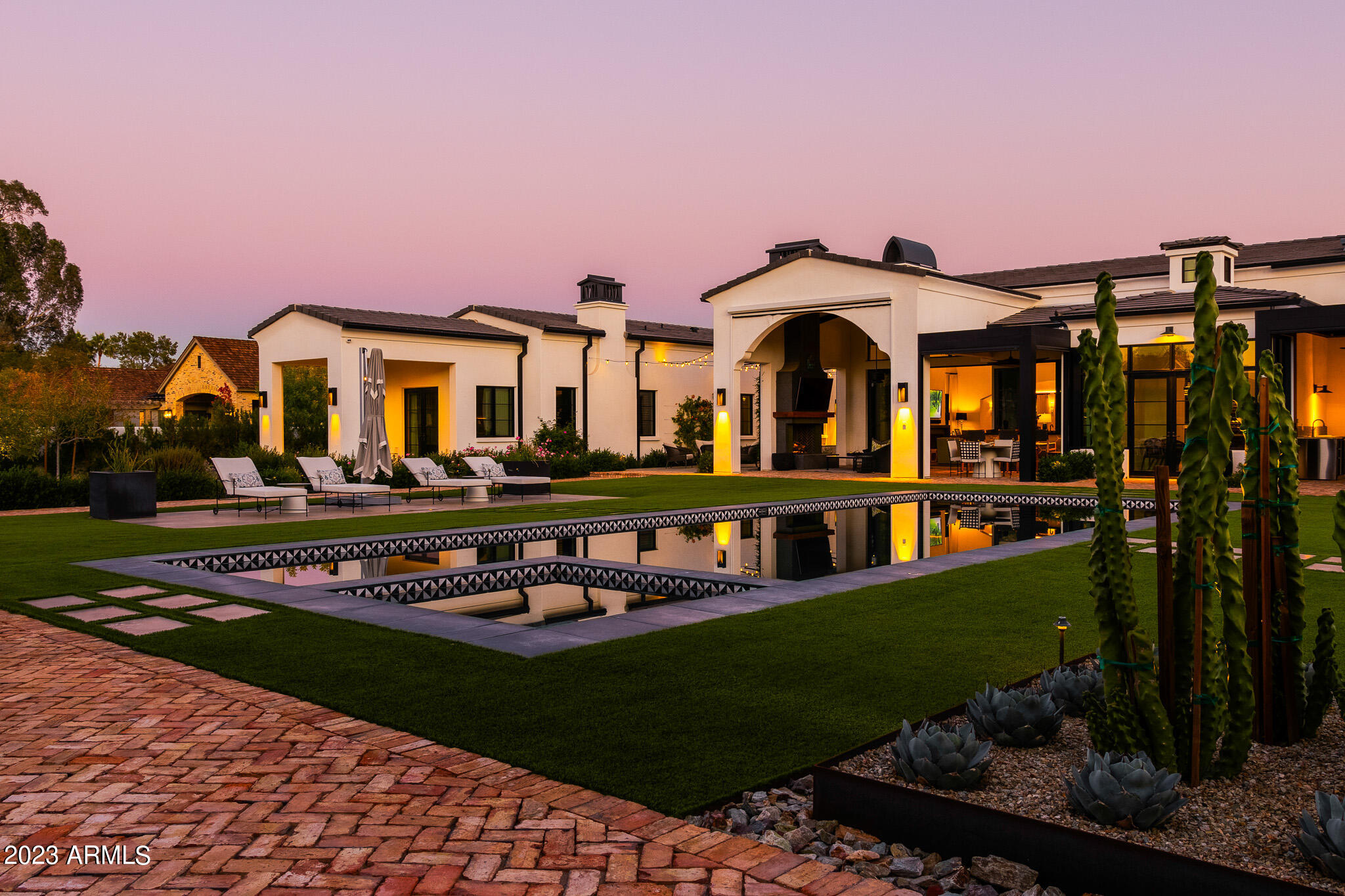 Welcome to the 2020 iconic house! Situated on over an acre, this luxury estate is sure to impress. As you enter the home, you are greeted with dramatic glass doors.that pull you in to a beautiful open floor plan which is perfect for entertaining. The focal point of the oversized living space is a stunning fireplace and includes vaulted ceilings with exposed beans and sliding doors to the rear patio. The chef's kitchen is gorgeous and functional with two islands, custom cabinetry, high end appliances and a wine cooler. Continue to the breakfast room with views to the backyard and pool. The family room features a coffered ceiling and boasts an additional bar and a climate-controlled wine room. The primary bedroom is inviting and relaxing, complete with fireplace, spa-like bath and a large closet. The resort-style backyard offers a sparkling swimming pool and spa and also offers a bocci ball court, additional oversized patios and an outdoor living room complete with seating area around the fireplace, bar access and outdoor kitchen. Three guest rooms are all en-suite and are adjacent to a stylish sitting room. Use the additional room as a home office or guest room. Don't miss this one before it's gone!