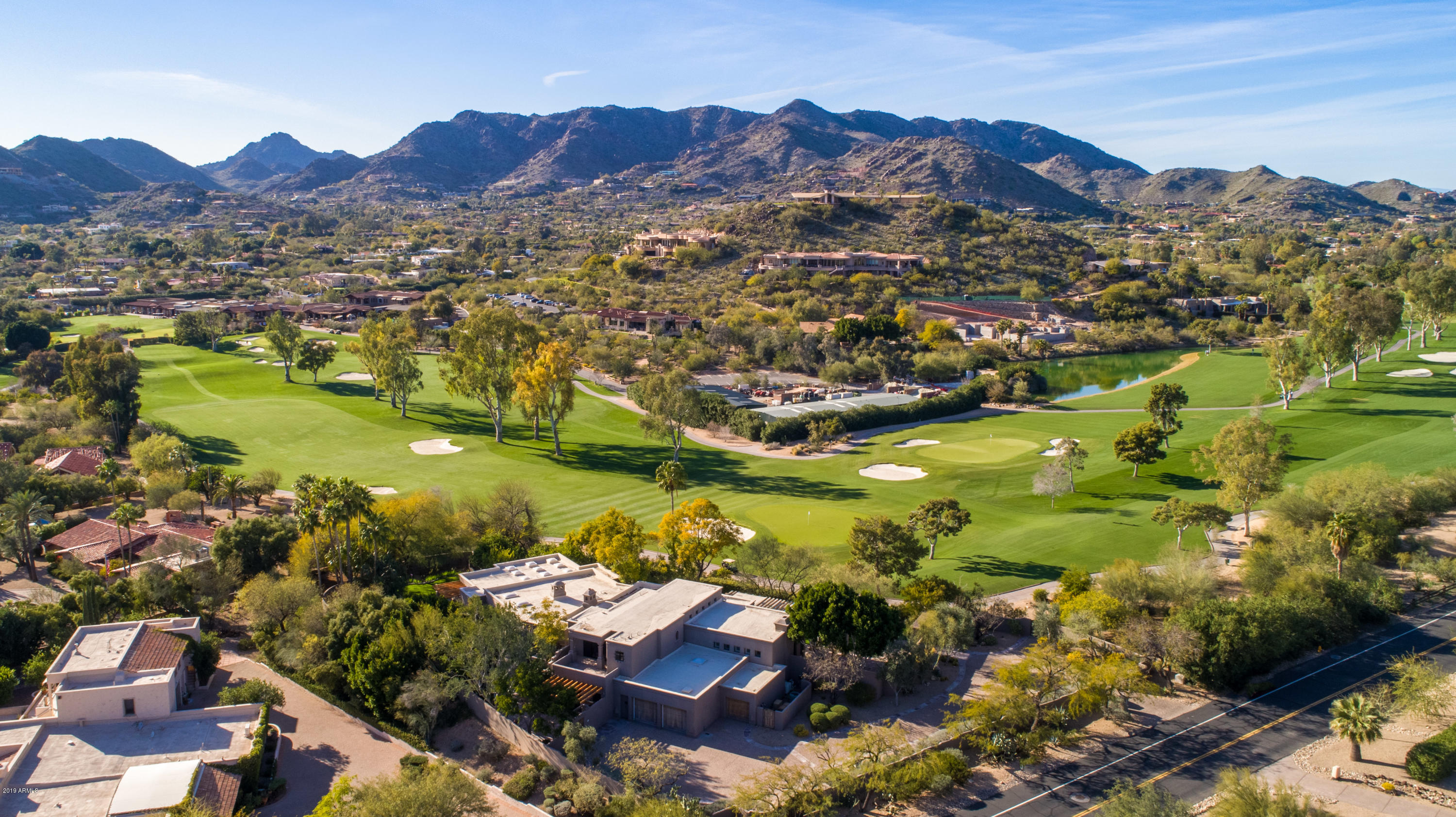 Absolutely STUNNING renovation of this timeless Paradise Valley Country Club Golf Course Double Gated Private Estate. Expertly designed for the current owner by renowned architect Bill Tull, this home is truly a work of art. Enter the private courtyard as you are greeted by the colorful lush grounds gazing across the perfectly manicured fairways to the surrounding mountains. Tull's SW artistry is found in the signature curved walls, flagstone and wood surfaces, 4 sculptured fireplaces, rare Sabino wood cabinetry, custom carved interior wood doors and massive beam ceiling details. The expansive walls are the perfect canvas to showcase the finest art collection. Spacious open floor plan includes massive great room/dining/den combo open to extraordinary chef's kitchen with antique finds incorporated throughout, new appliances, custom island, wine fridge and disappearing walls to both the front and back patio areas. There are 3 bedrooms plus separate office with en suite baths and open to outdoor patios/balcony.
The grand master suite overlooks the rear grounds and is accented by the massive fireplace. The separate his and her bath areas offers her side with all new finishes throughout with Travertine accents, custom lighting, new champagne bubble tub and two huge closets with skylights. His side offers large glass shower, soaking tub, two sink areas, another large shower and a private door to adjacent office/den. Split on the main level is one secondary guest suite. Upstairs find a charming loft adjacent to upstairs guest suite with private balcony leading to the sparkling all tile pool and spa with waterfall and cozy fireplace sitting area. The magical home is a special classic jewel and sits on one of the most prestigious sites in all of Paradise Valley. It truly is the definition of comfortable elegance.