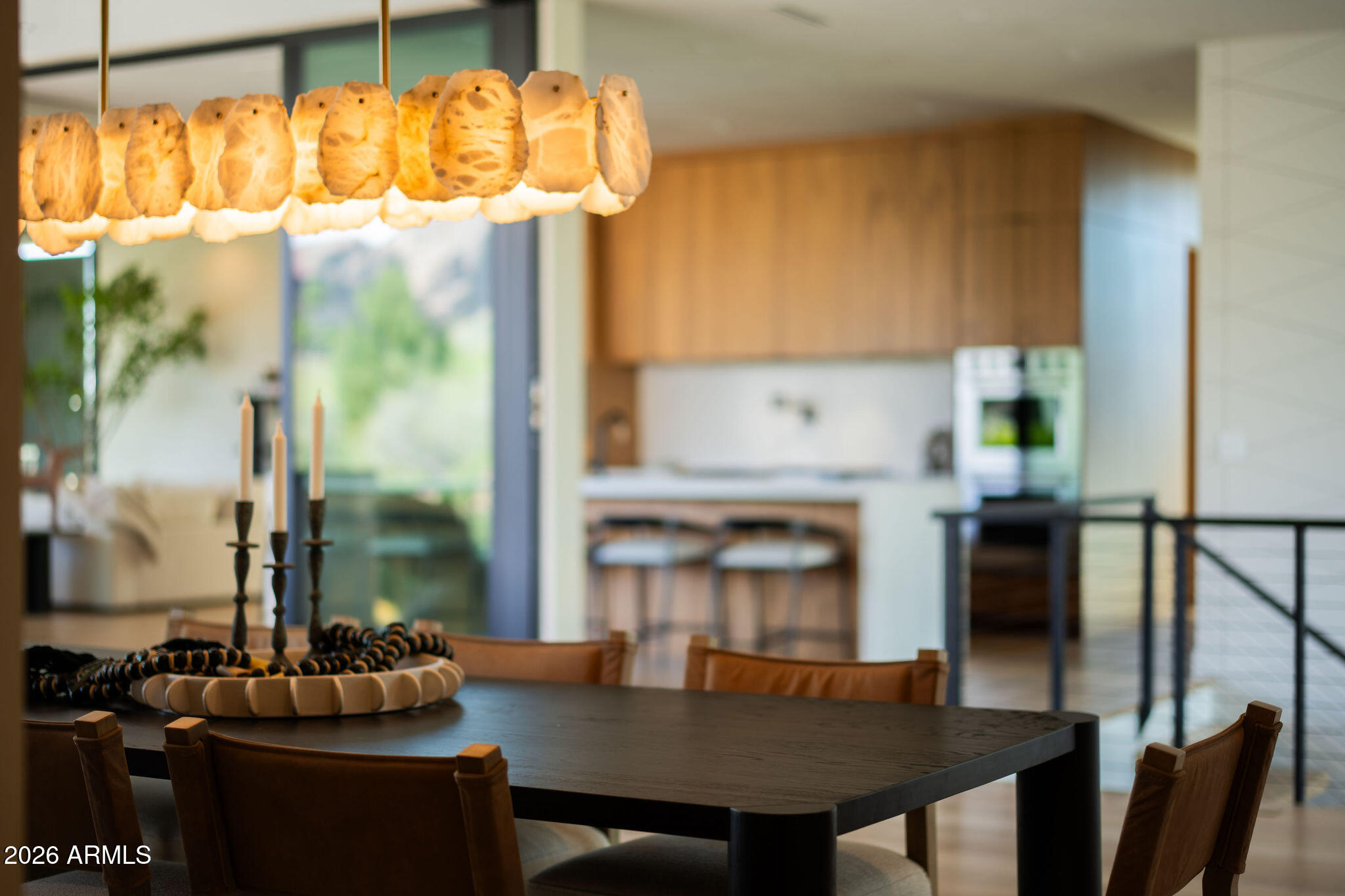 Situated on the coveted Arcadia-Paradise Valley border, this gated modern residence blends privacy, sophistication, and sweeping mountain views. A lush ficus hedge frames the property, while floor-to-ceiling windows and sliding glass walls capture Camelback Mountain and the Phoenix Mountain Preserve. The main level features a Wolf/Sub-Zero chef's kitchen with hidden prep space, open living areas, and three en-suite bedrooms including a primary retreat with fireplace, spa bath, custom closet with secondary laundry, and private balcony. The lower level offers two additional en-suites, a flex room, and an entertainment lounge with bar. Smart home automation and seamless indoor-outdoor living make this home ideal for both everyday living and elevated entertaining.