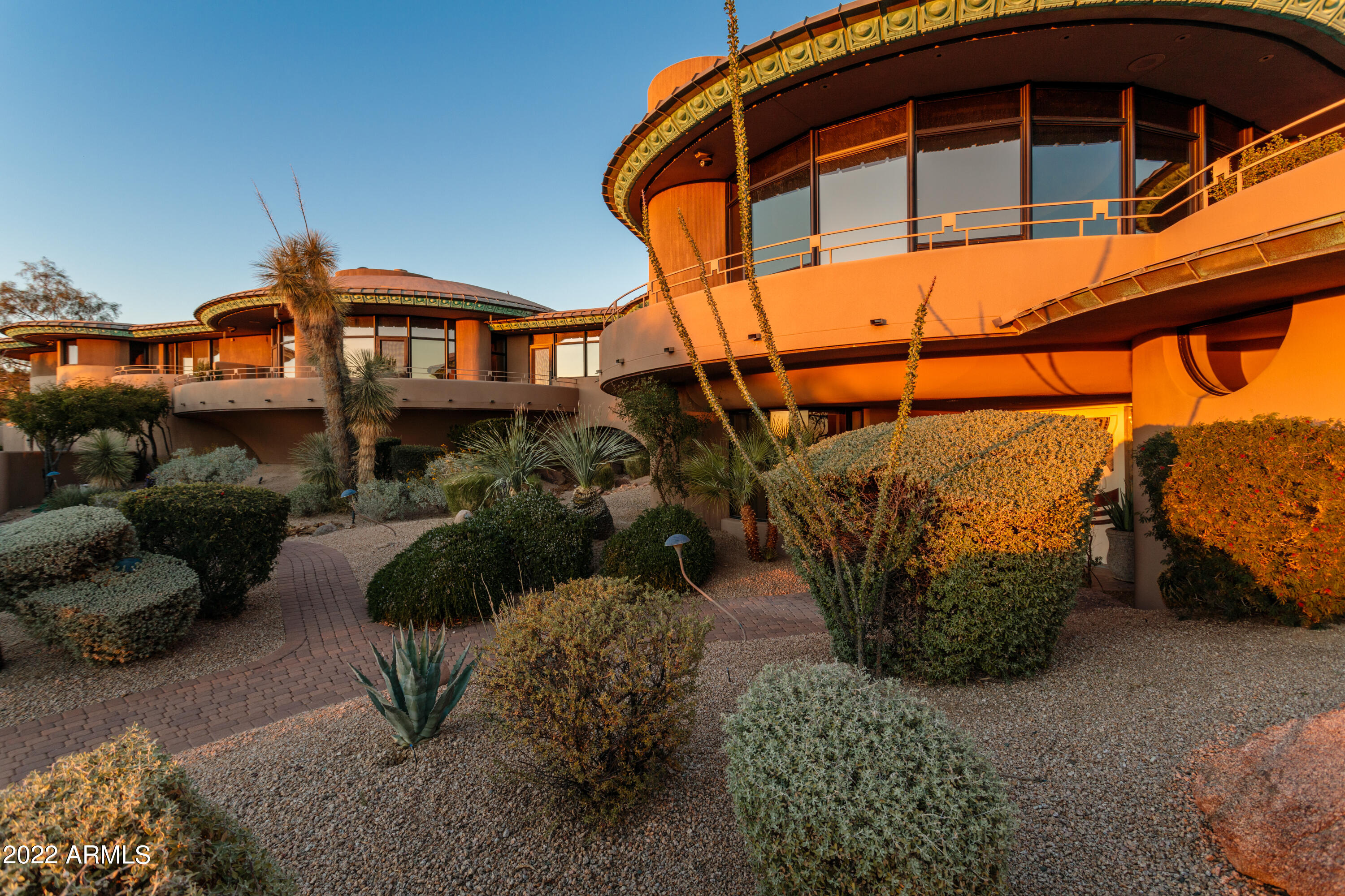 Designed by Frank Lloyd Wright apprentice/Taliesin Architect, John Rattenbury, Myers Residence is a VERY SPECIAL! This Wright protégé designed continuous curves nestled into Pinnacle Peak boulders: 10,000SF+- this one has it all!  Decorative details echo desert shapes/colors. Generous spaces - huge owners suite, guest rooms, in-house guest-suite, work-out w/sauna, offices. Entertainers dream: generous kitchen, formal dining, family/living rooms, elevator. Separate guest house. Resort like setting: pool w/boulders; outdoor cabana BBQ, shower, pool-bath. Garage parking for 5, storage/shop space. VERY private gated lot. Nearly irreplaceable! Combines 4 lots! Hillside setting w/ AWESOME views/sunsets. Recently refreshed:wood/stone floors, fresh paint, carpet, updated faucets, appliances...WOW! Desert Highlands amenities include Jack Nicklaus Signature golf course, driving range, 18 hole putting course (nearly 400 yds), Racquet club and 13 tennis courts (4 grass), 2 pickleball courts, 2 bocce ball courts, 10,000/sf fitness center, clubhouse dining, walking paths, guard gated & security patrolled.

Contact Listing Agents regarding DH membership/transfer fee to be settled at close of escrow.